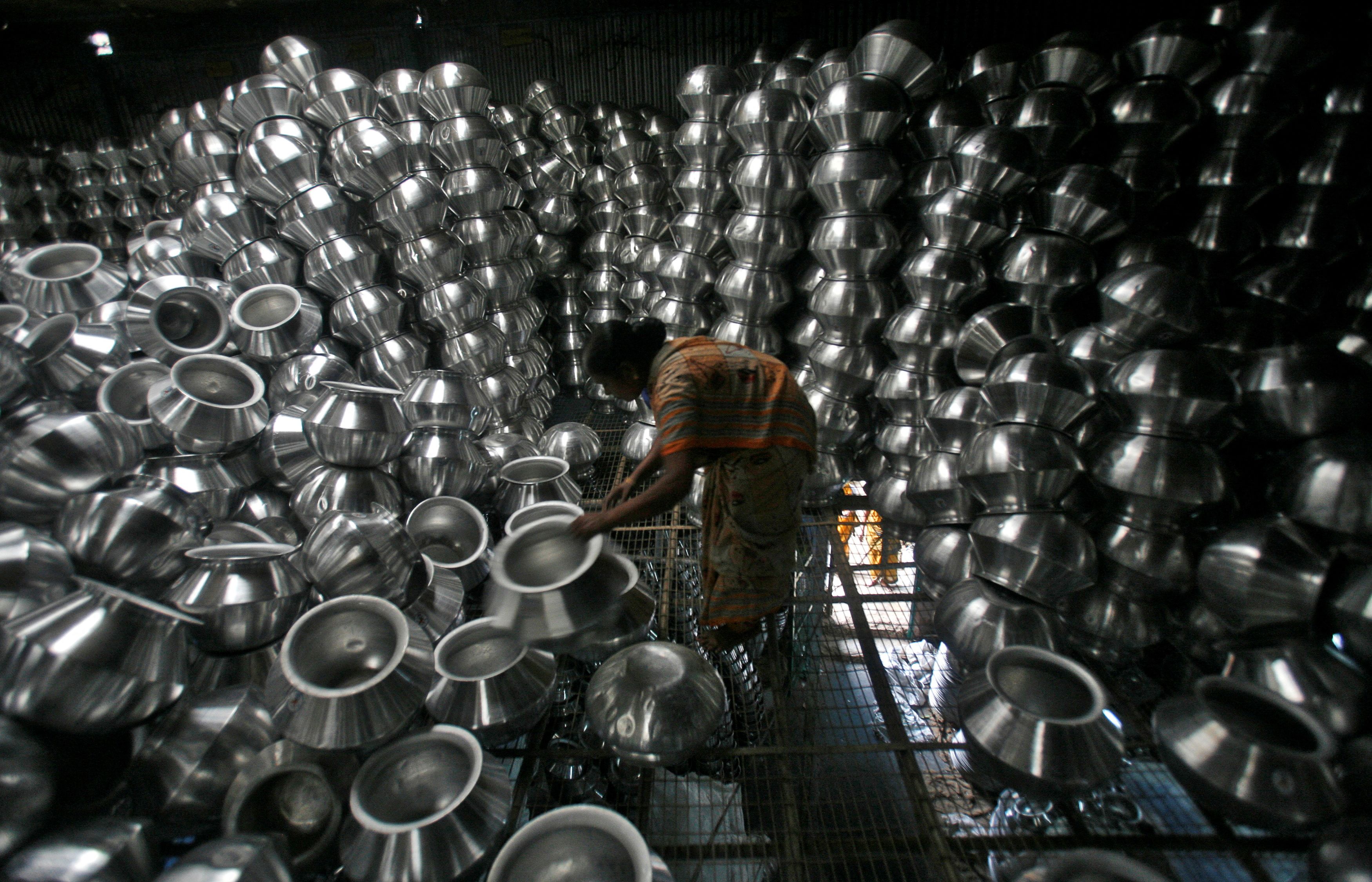 A worker checks aluminium utensils inside a factory on the outskirts of Agartala