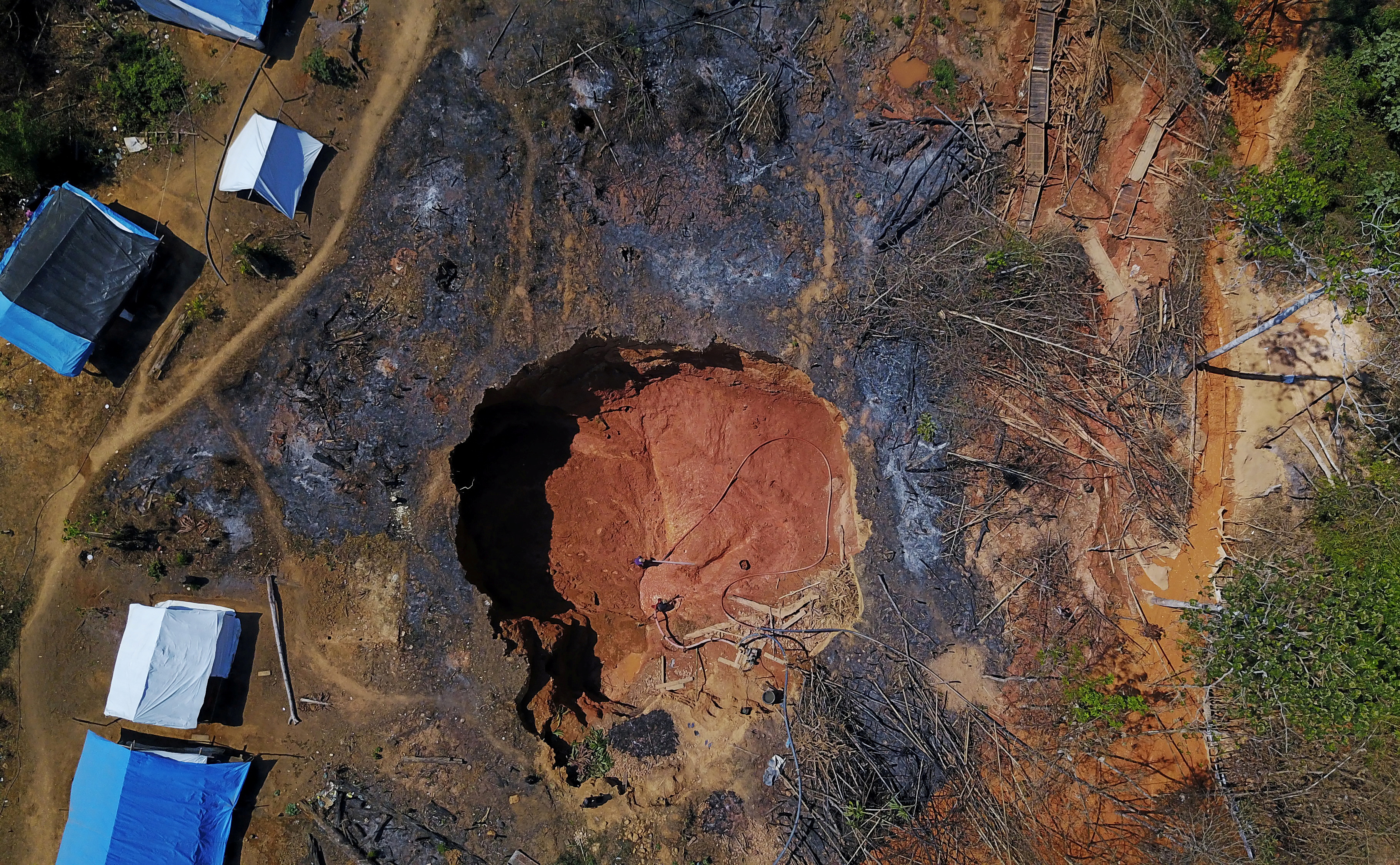 Aerial view shows a wildcat gold miner, or garimpeiro, as he uses high-pressure jets of water to dislodge rock material at a wildcat mine, also known as garimpo, at a deforested area of Amazon rainforest near Crepurizao