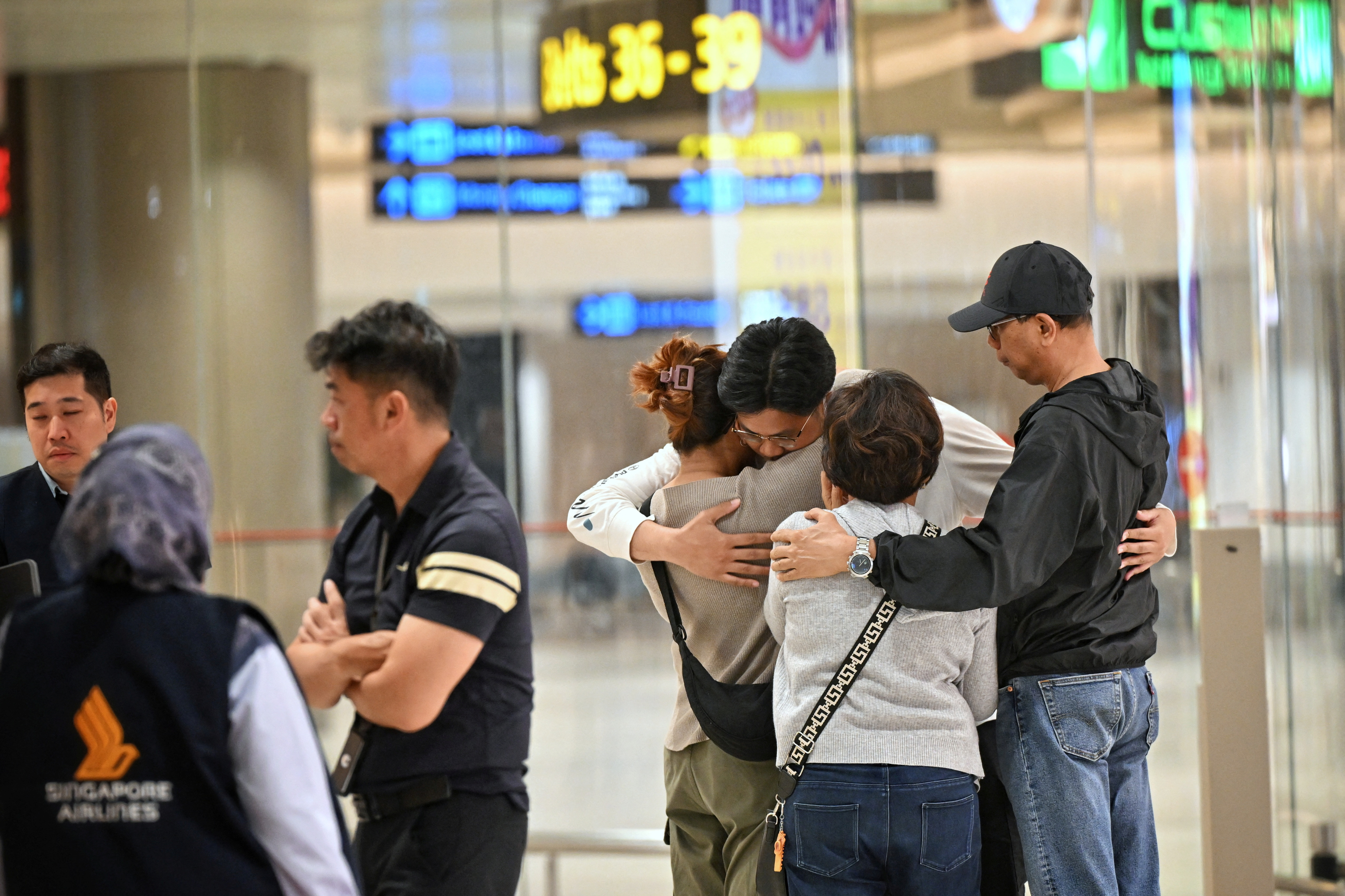 Passengers who were on board the flight SQ321 from London arrive at Changi Airport, in Singapore