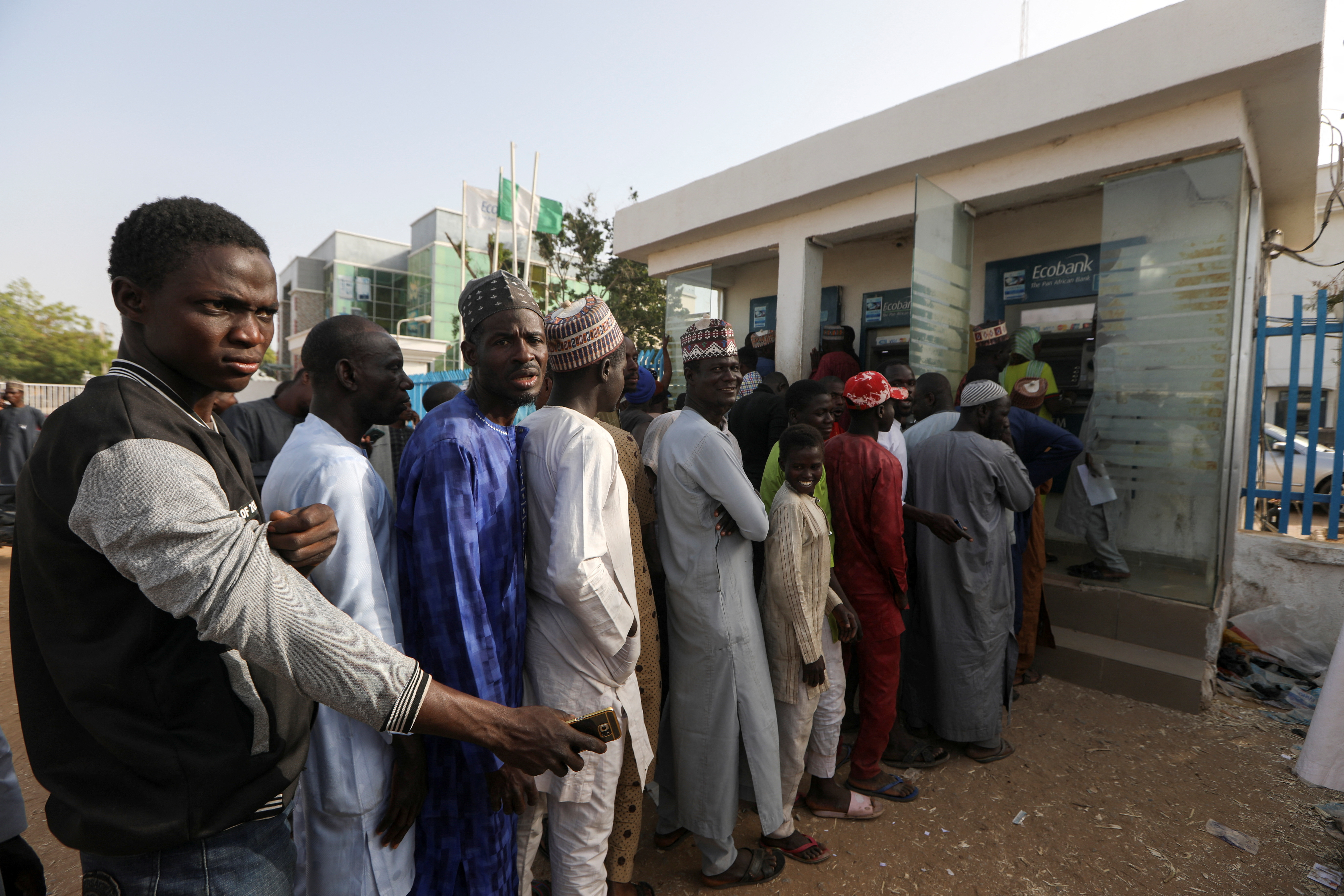 People queue to withdraw cash from an ATM at a bank, ahead of presidential elections, in Zamfara