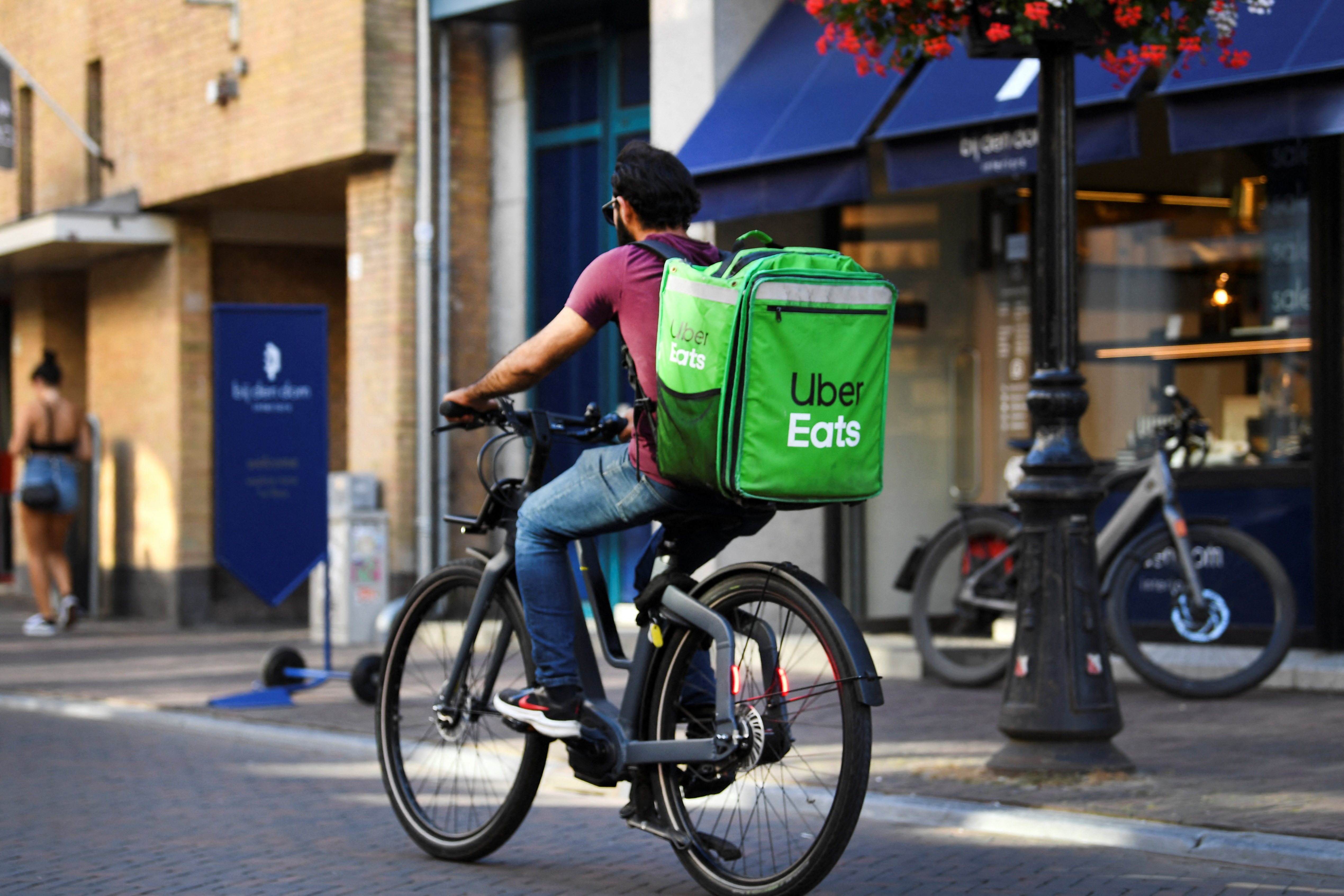A bicycle courier from Uber Eats rides his bicycle during the heatwave in Utrecht