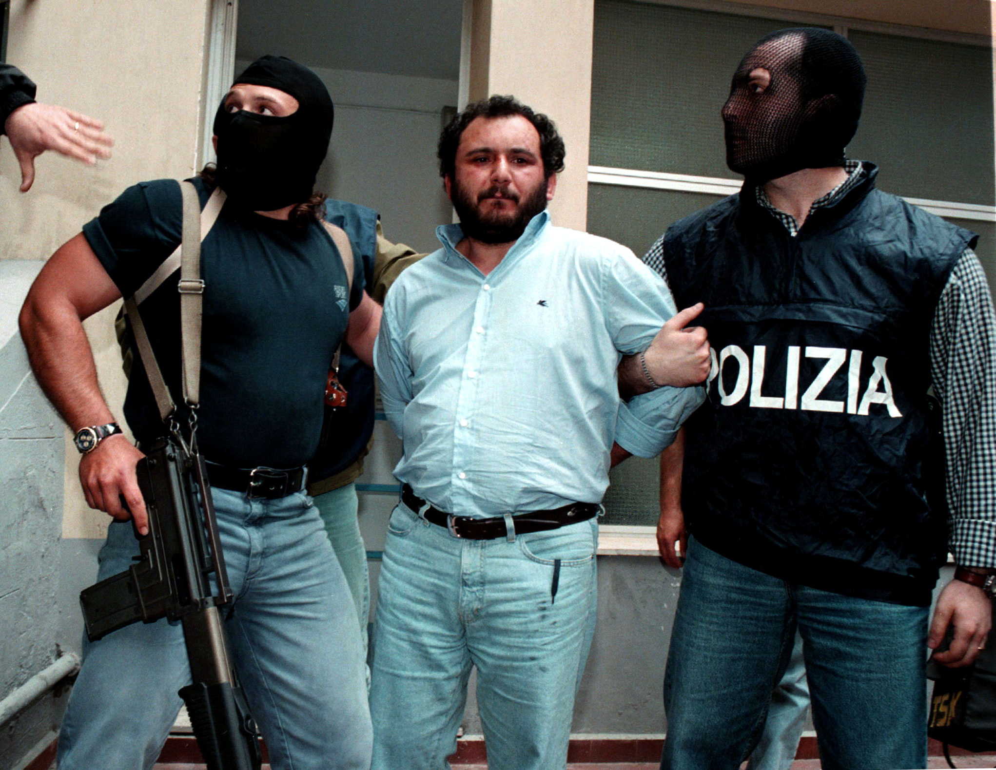 Anti-Mafia police wearing masks to hide their identity, escort top Mafia fugitive Giovani Brusca May..