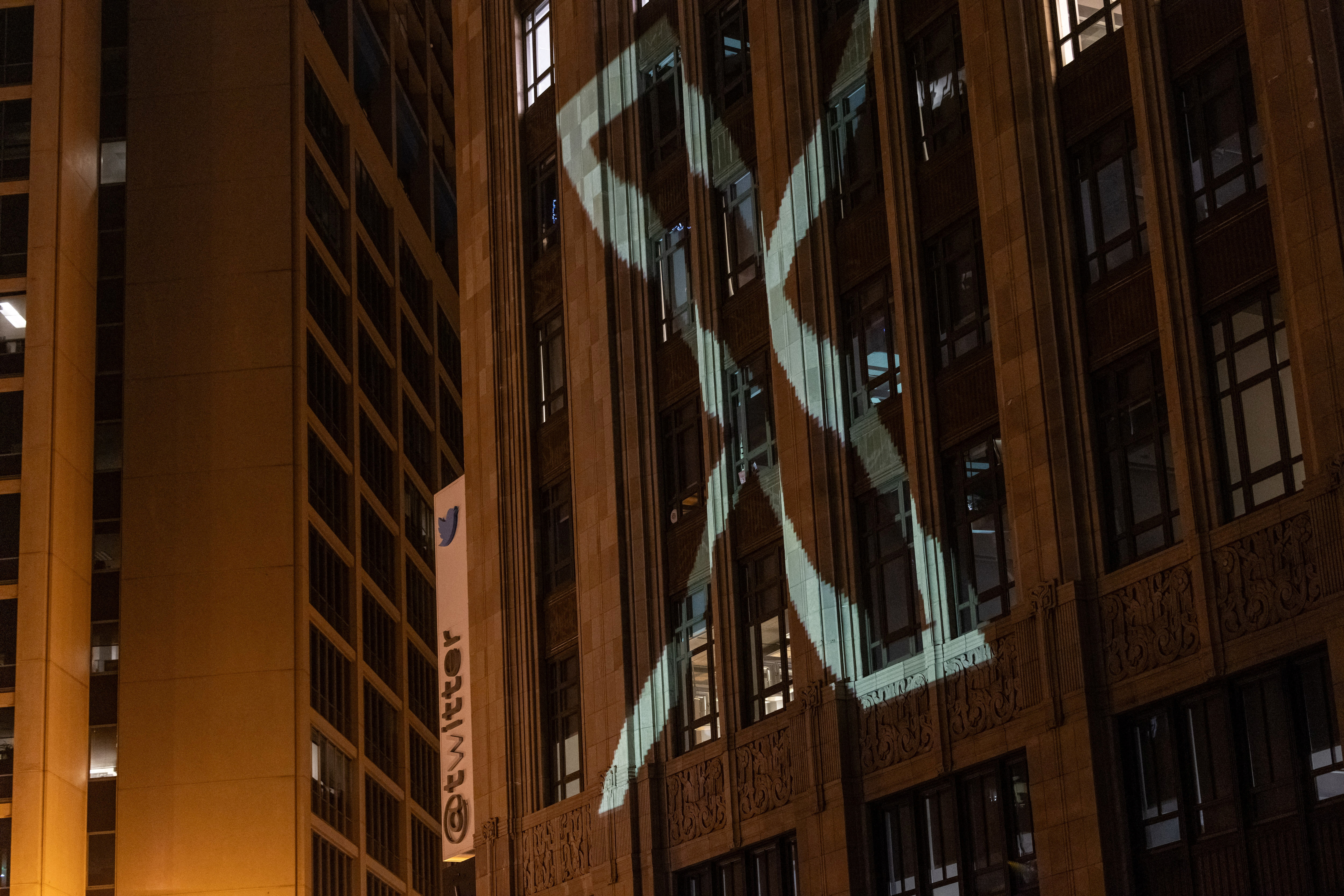 Twitter's new logo is seen projected on the corporate headquarters building in downtown San Francisco, California