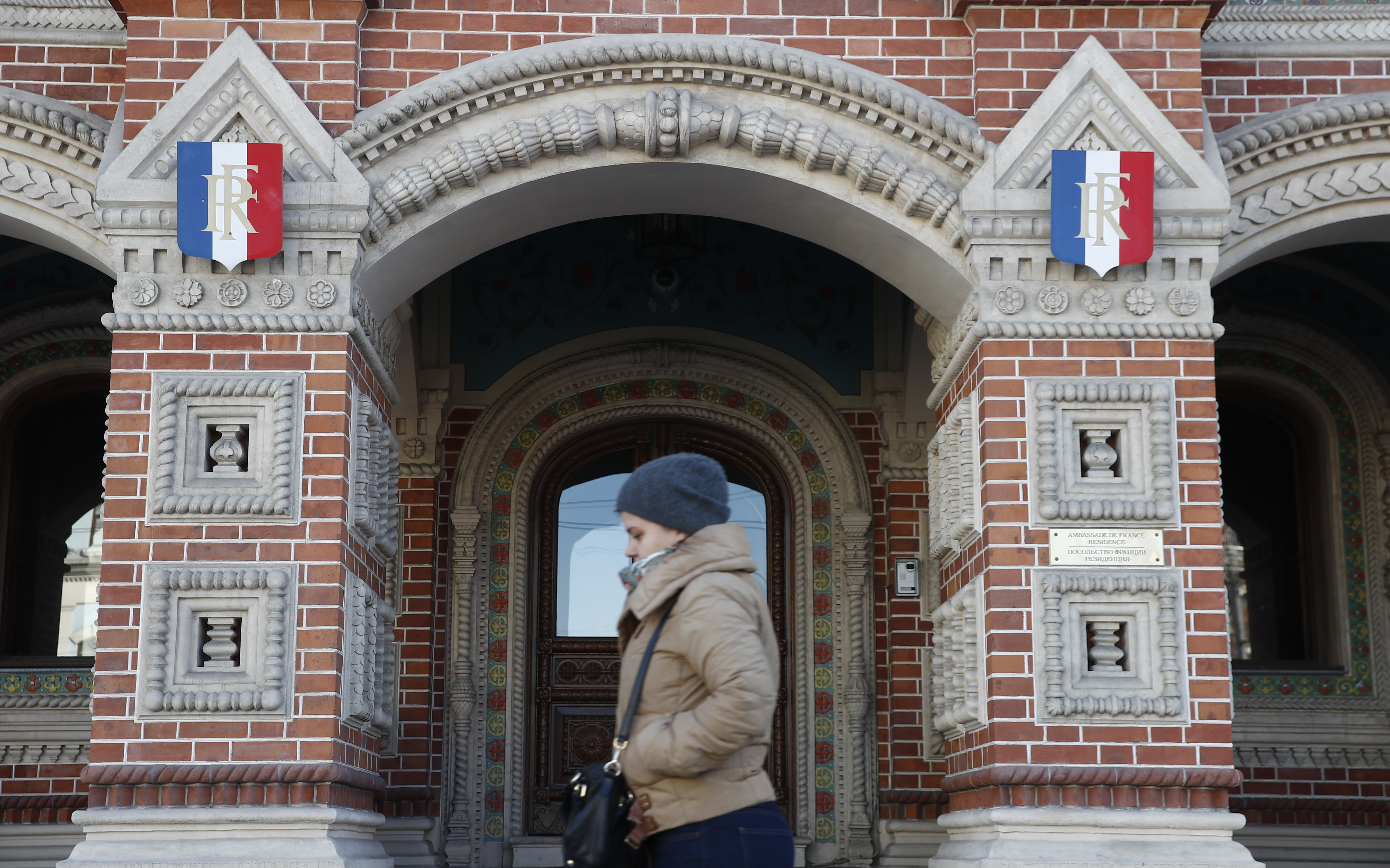 A woman walks past the embassy of France in Moscow