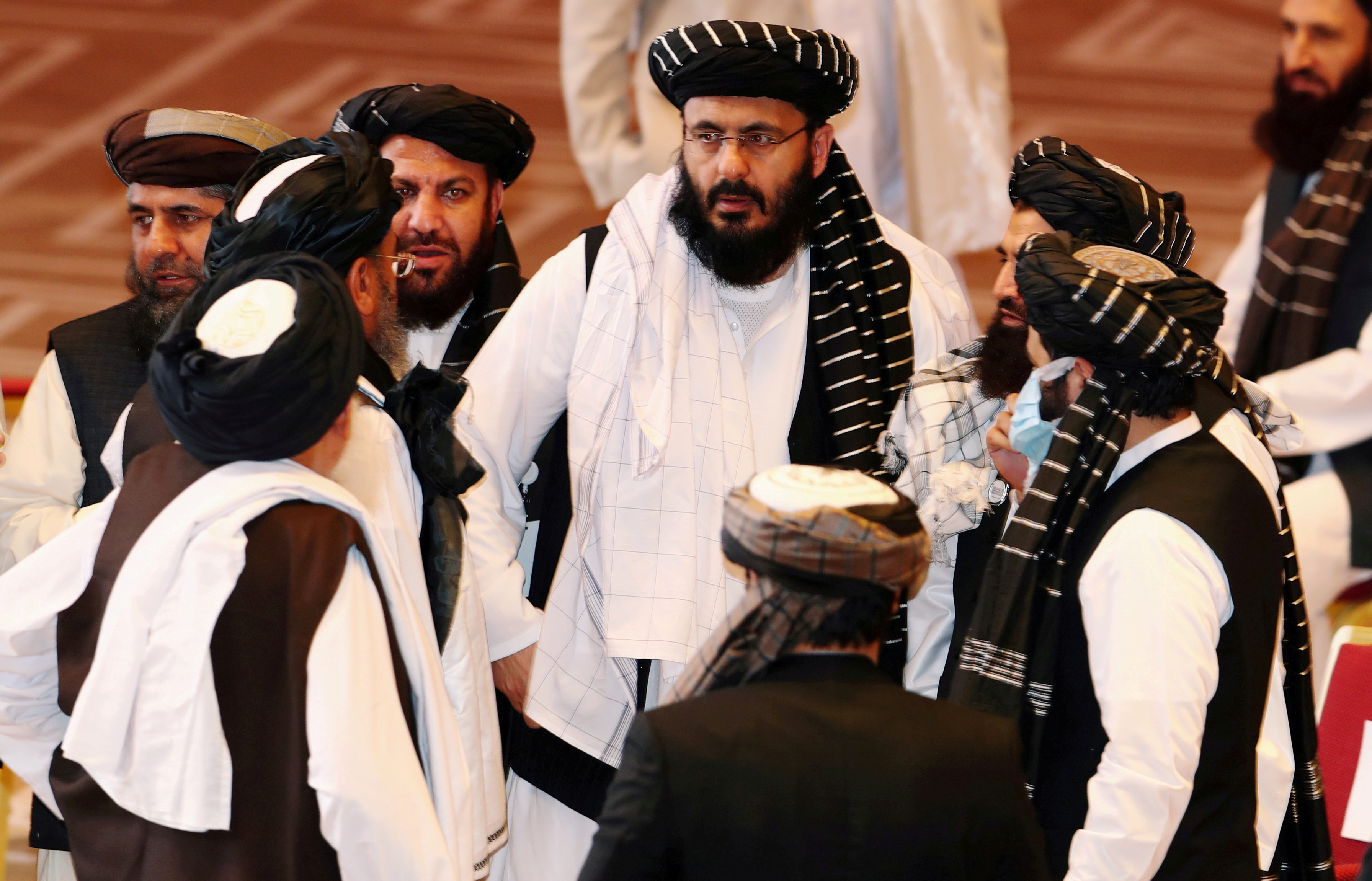 Taliban delegates speak during talks between the Afghan government and Taliban insurgents in Doha, Qatar