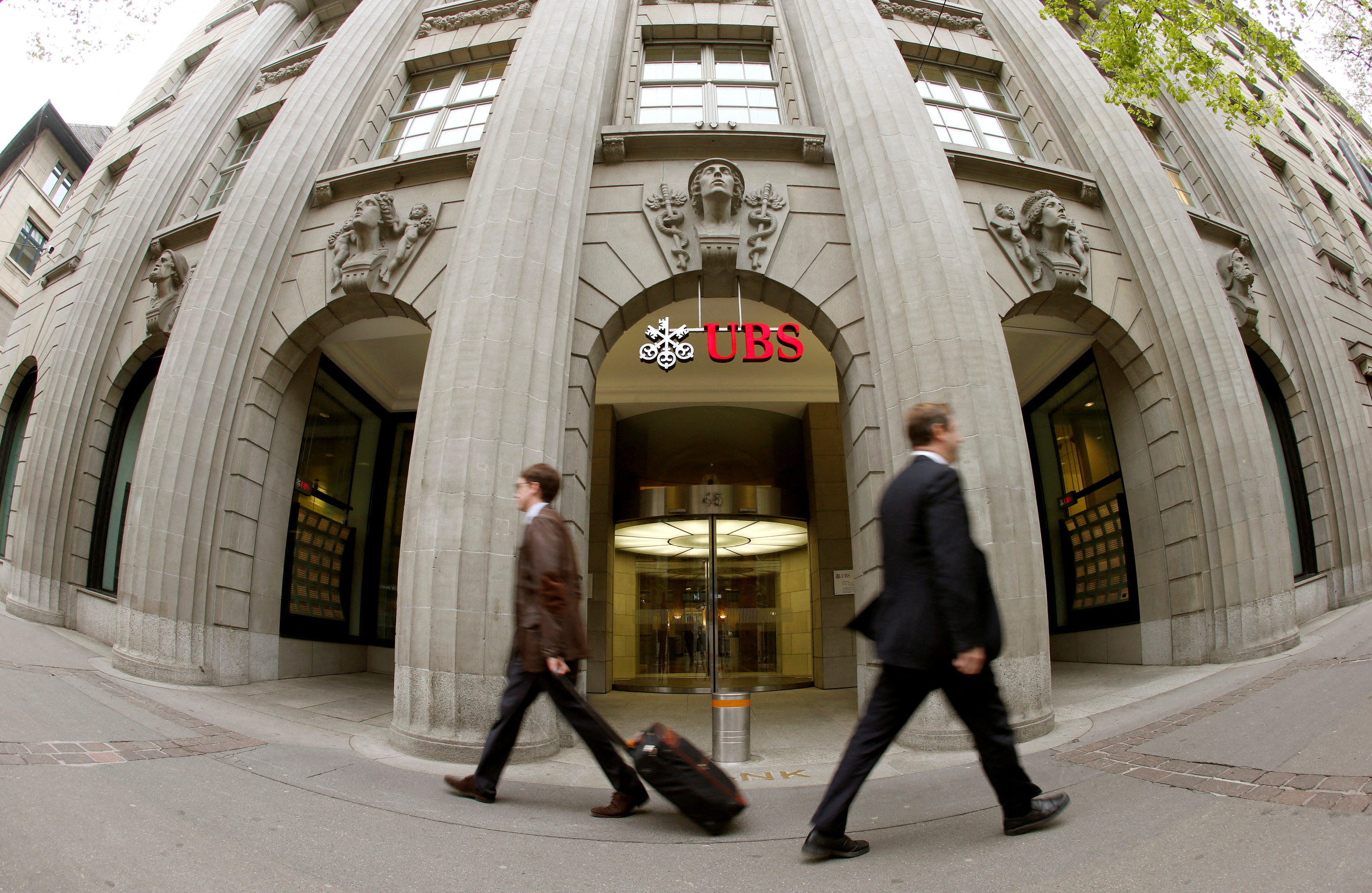 People walk past the headquarters of Swiss bank UBS in Zurich