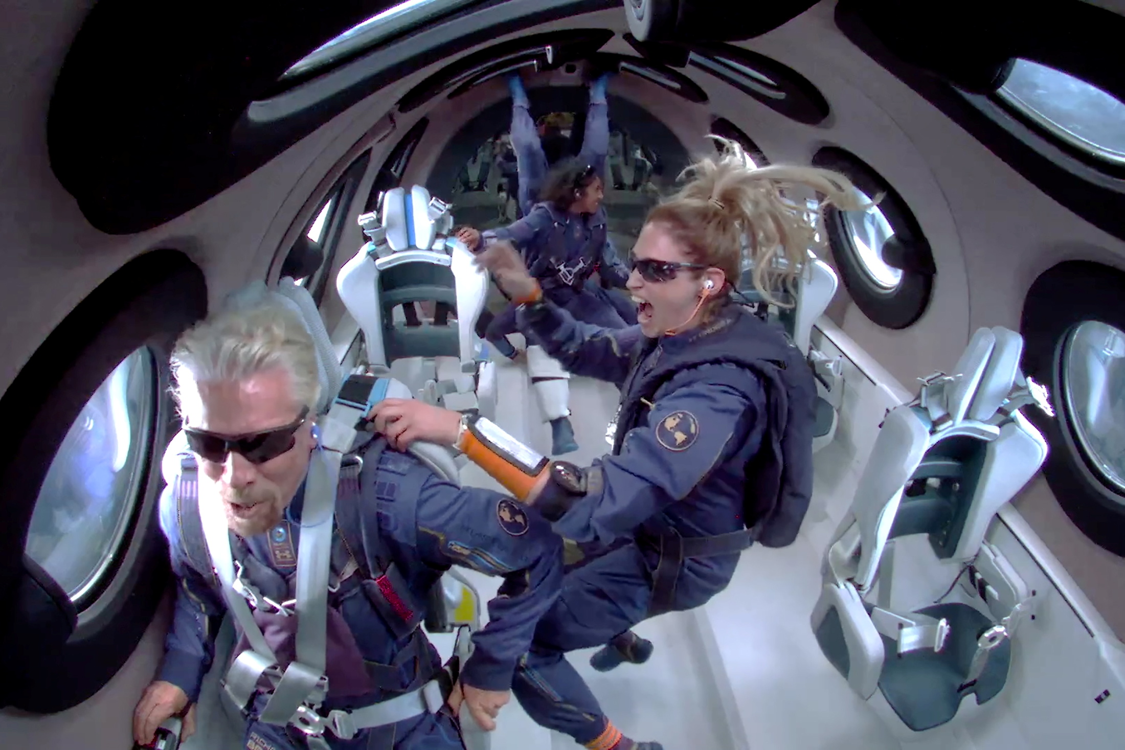 Billionaire Richard Branson speaks as crew members float in zero gravity above Spaceport America