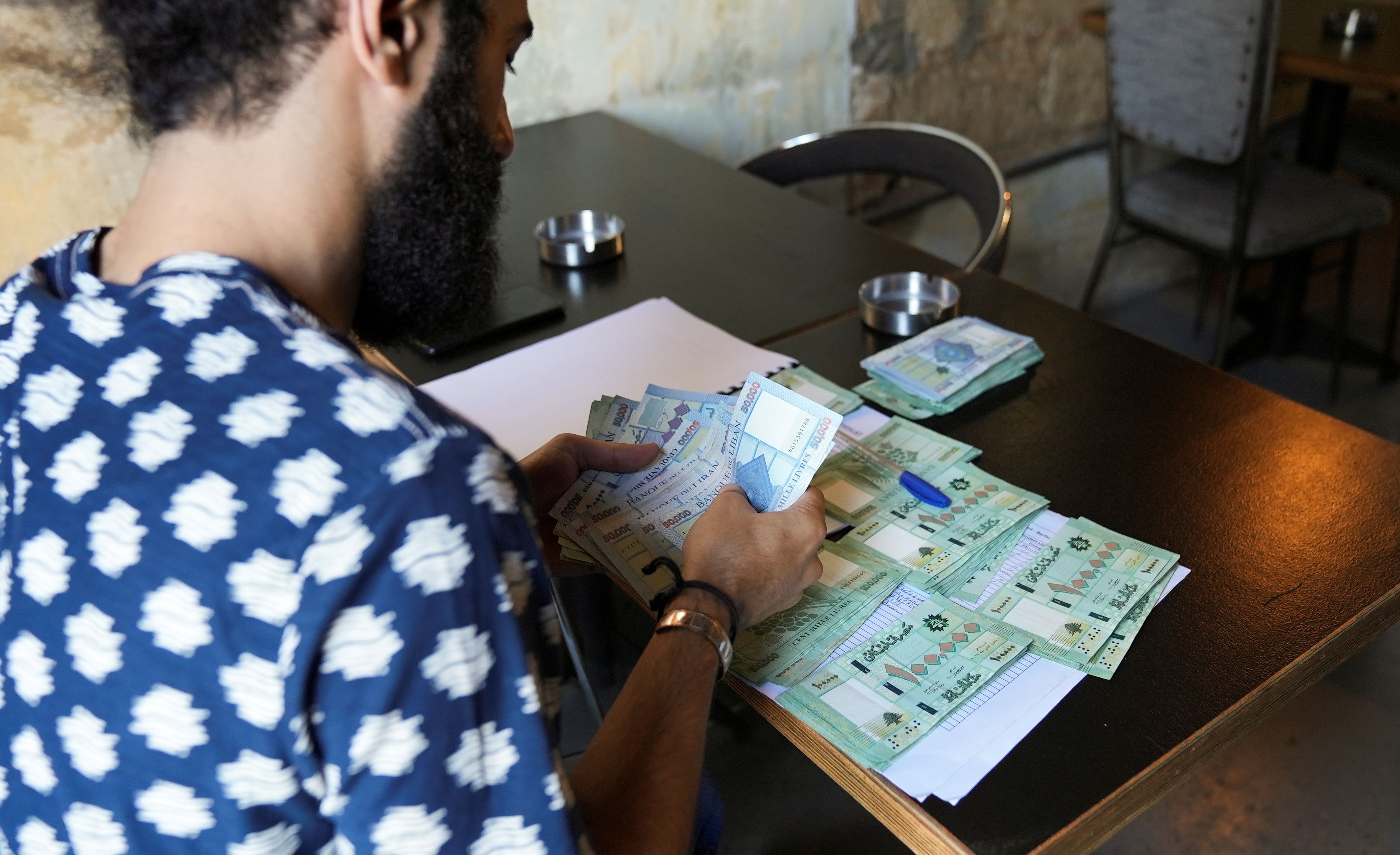 Moussa Yaakoub, a Lebanese pub owner, counts Lebanese pound banknotes in Beirut