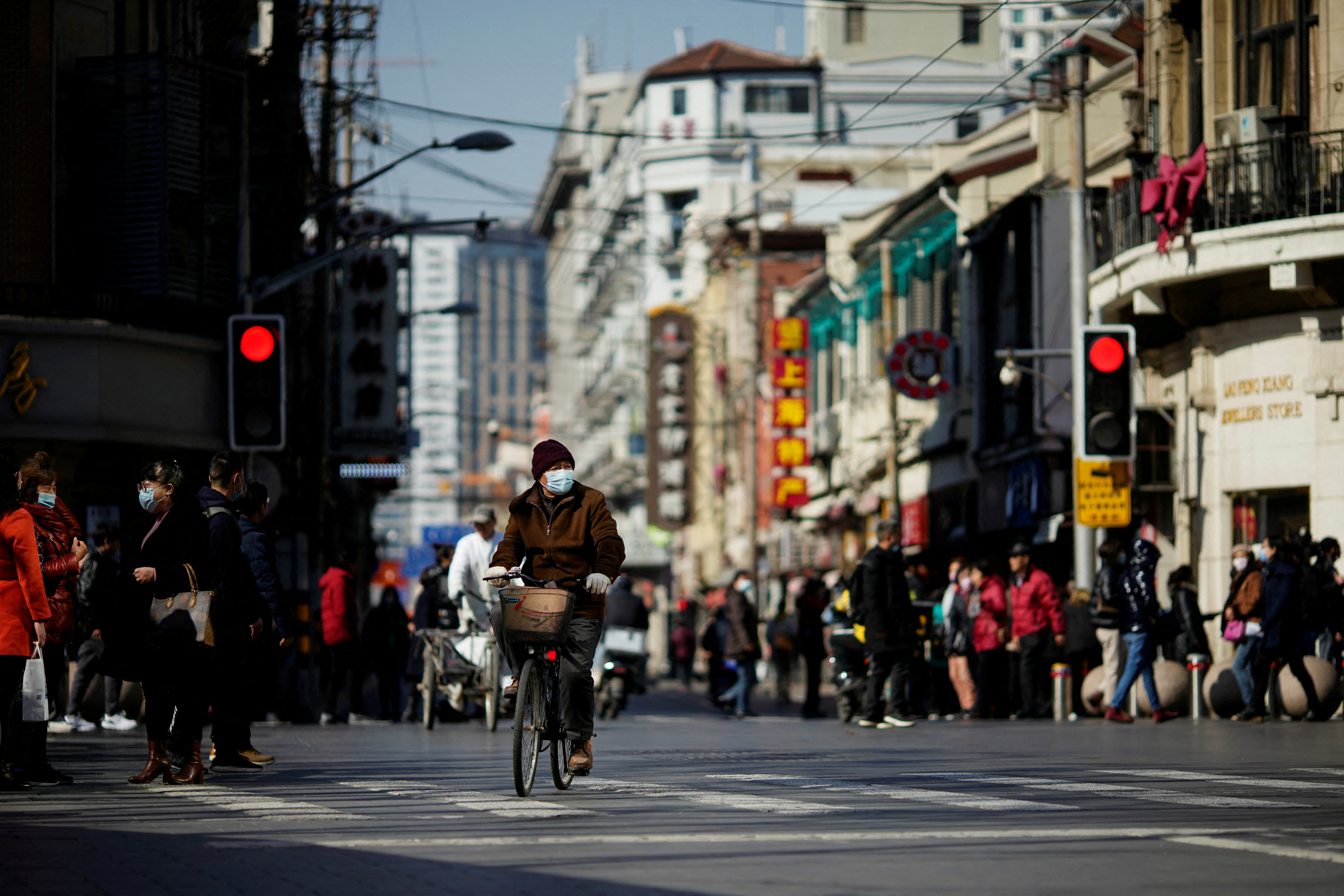 Man wearing mask rides bicycle in Shanghai