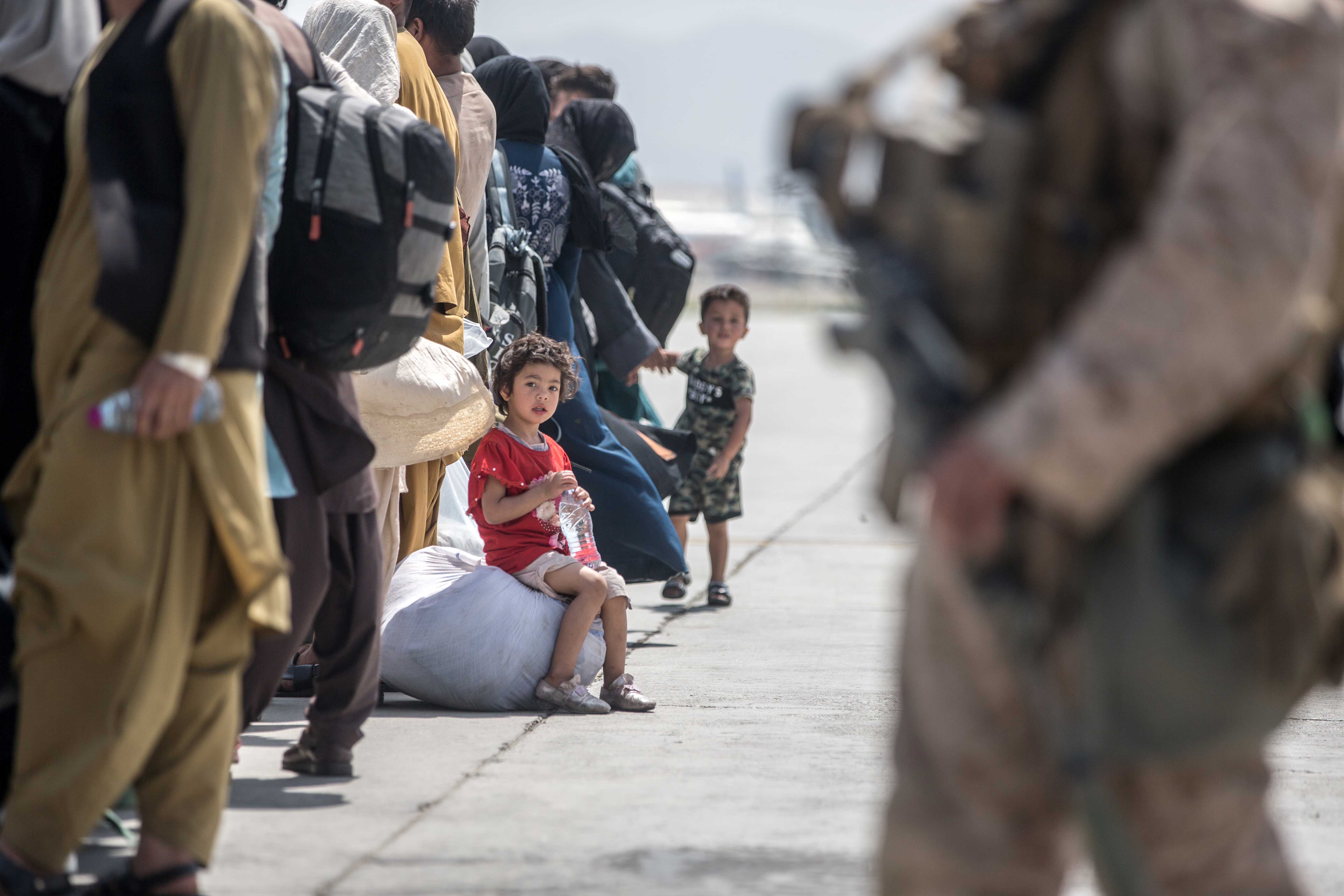 A child waits with her family to board a U.S. Air Force Boeing C-17 Globemaster III during an evacuation at Hamid Karzai International Airport, Afghanistan, August 22, 2021. U.S. Marine Corps/Sgt. Samuel Ruiz/Handout via REUTERS