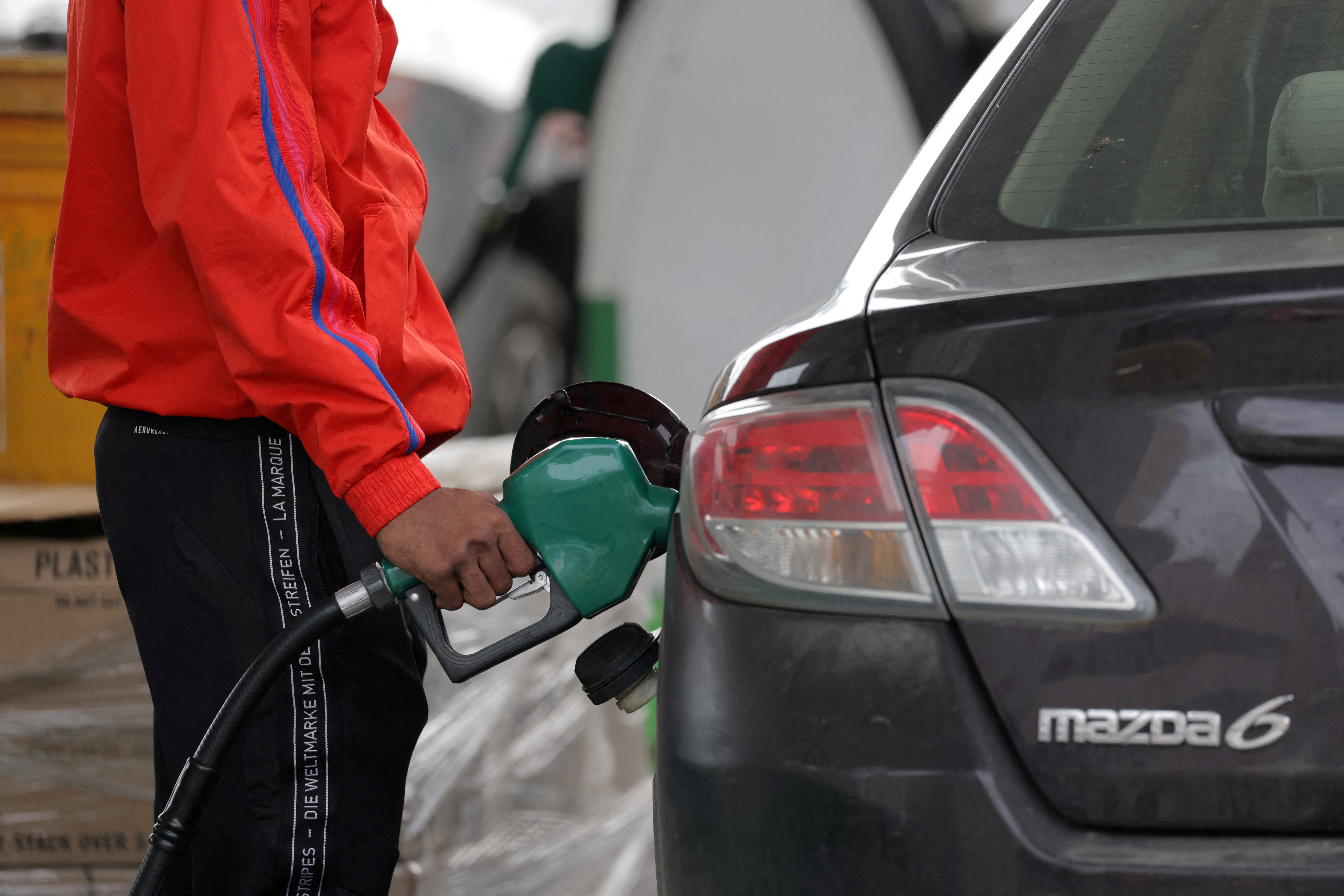 A person uses a petrol pump at a gas station as fuel prices surged in Manhattan, New York City