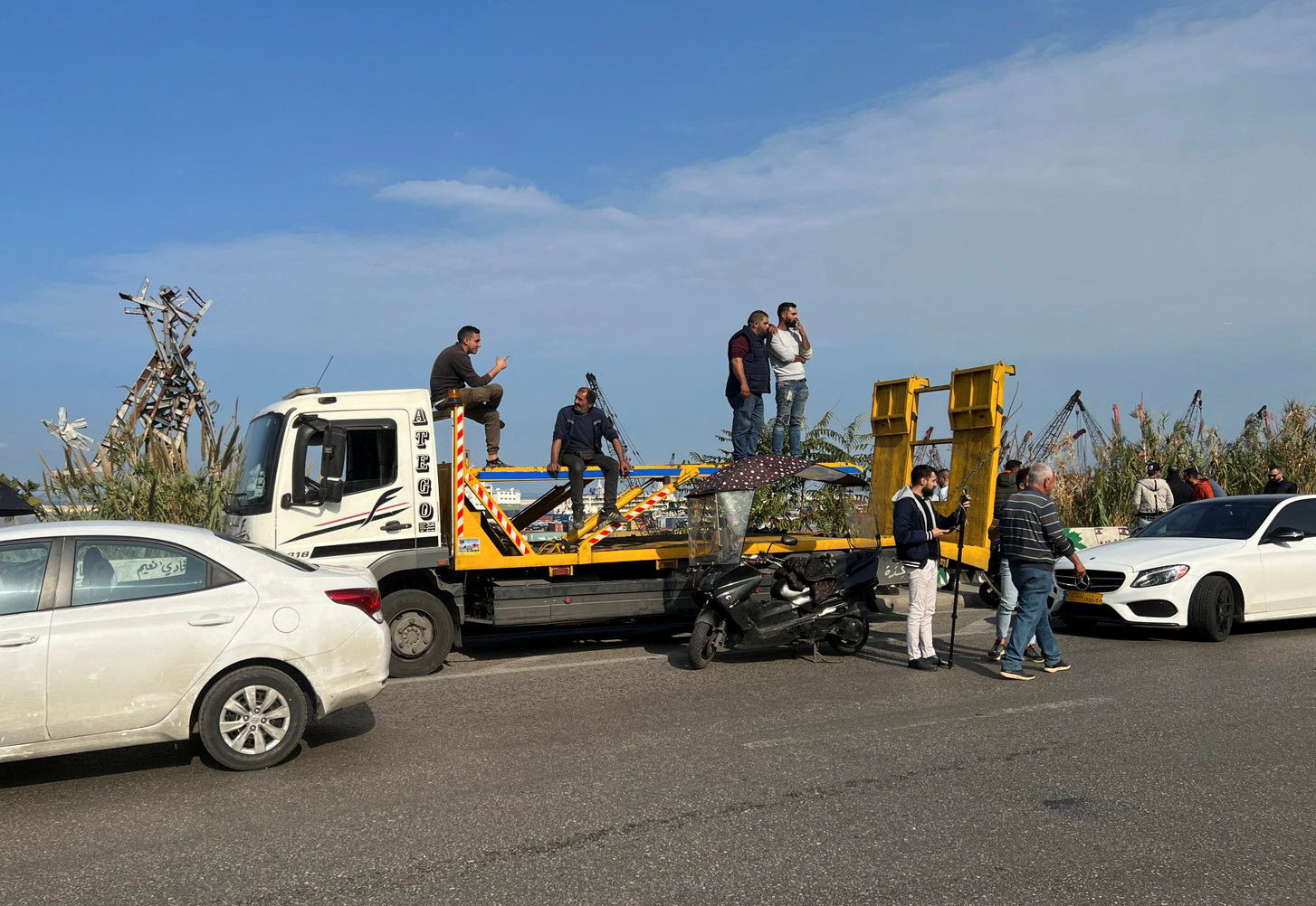 Workers in car dealerships sit on a truck during a protest against tariff hikes in Beirut