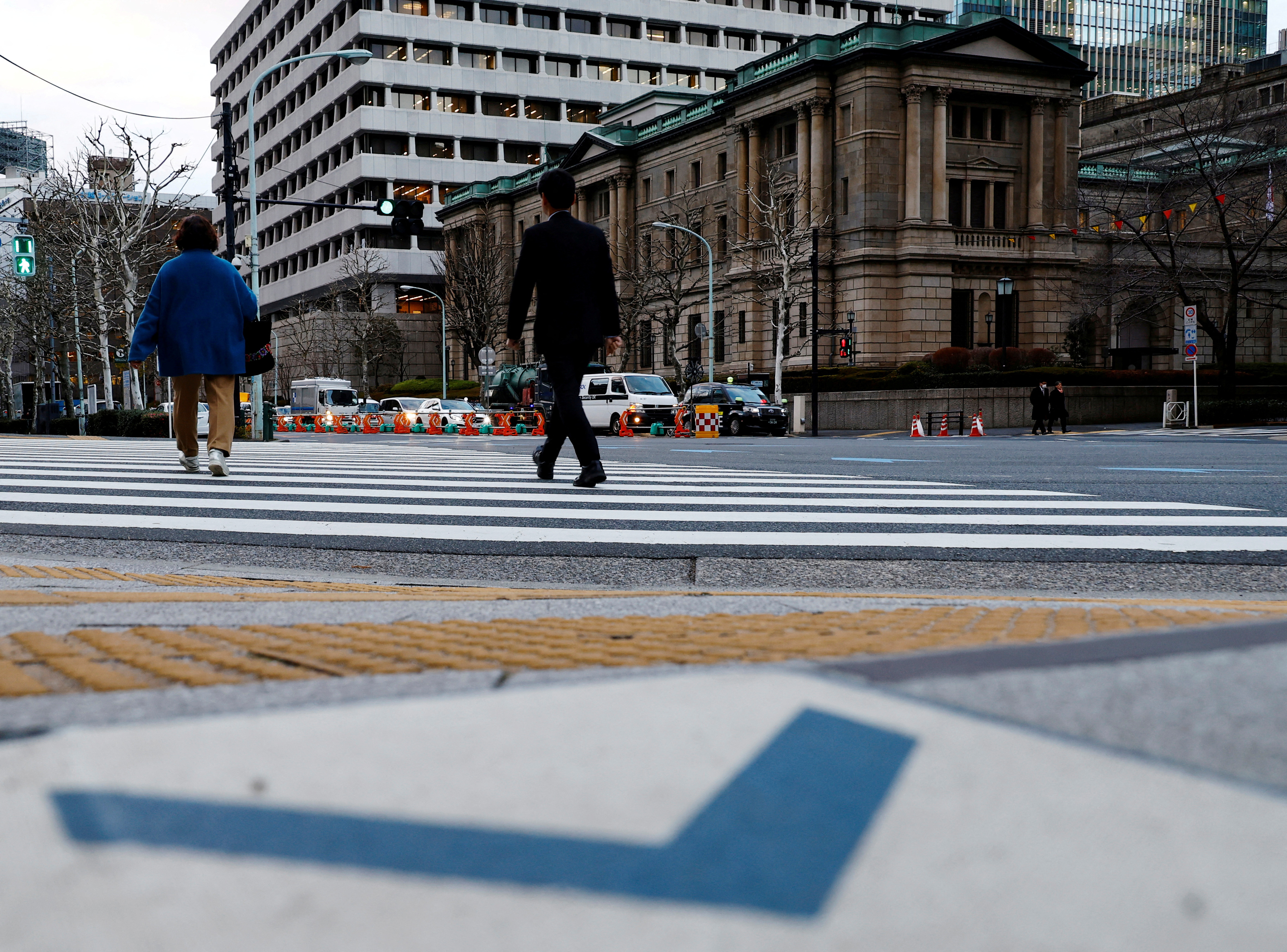 People walk in front of the Bank of Japan building in Tokyo