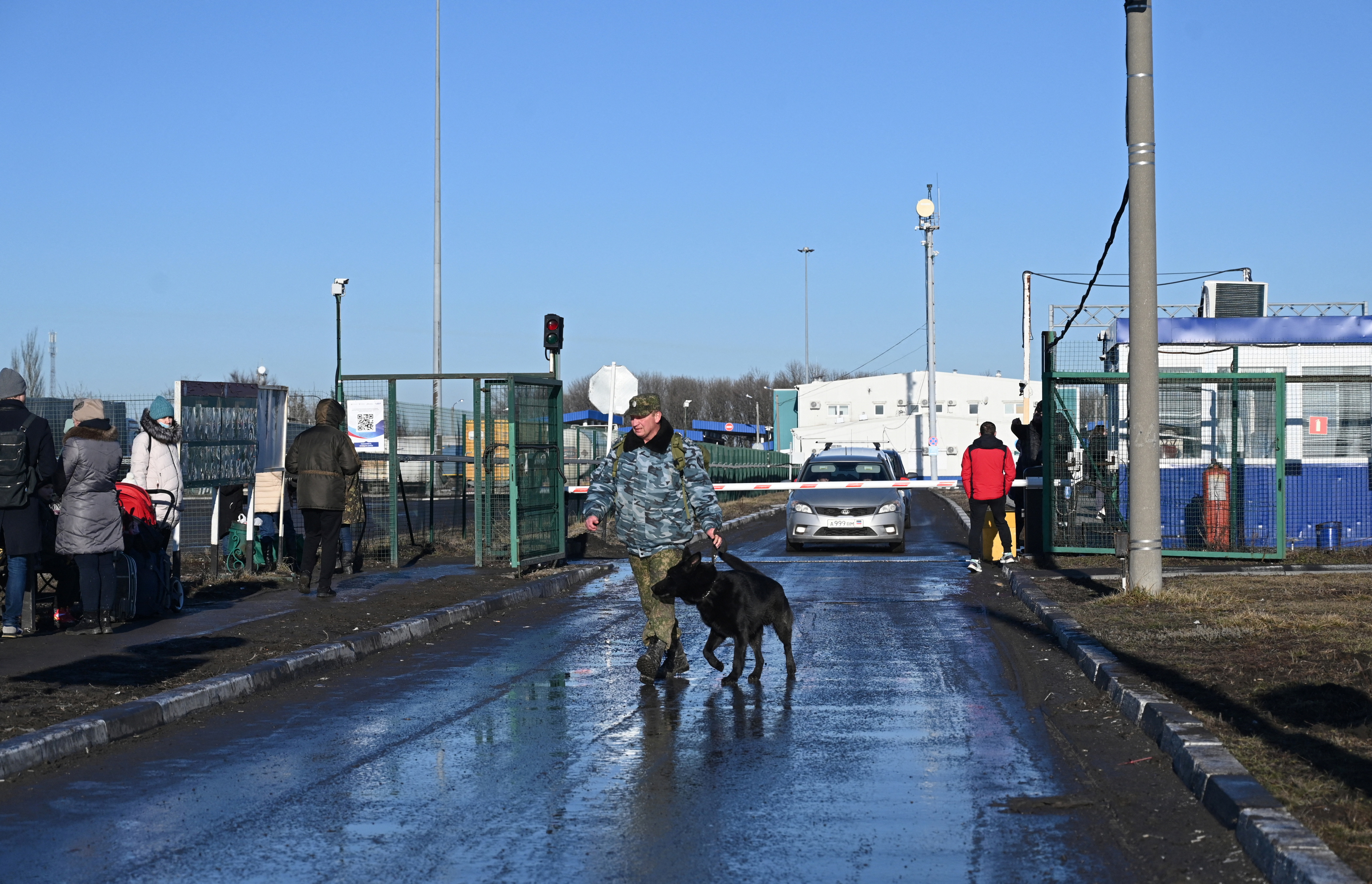 A border guard walks with a dog at the Matveyev Kurgan border checkpoint in the Rostov region
