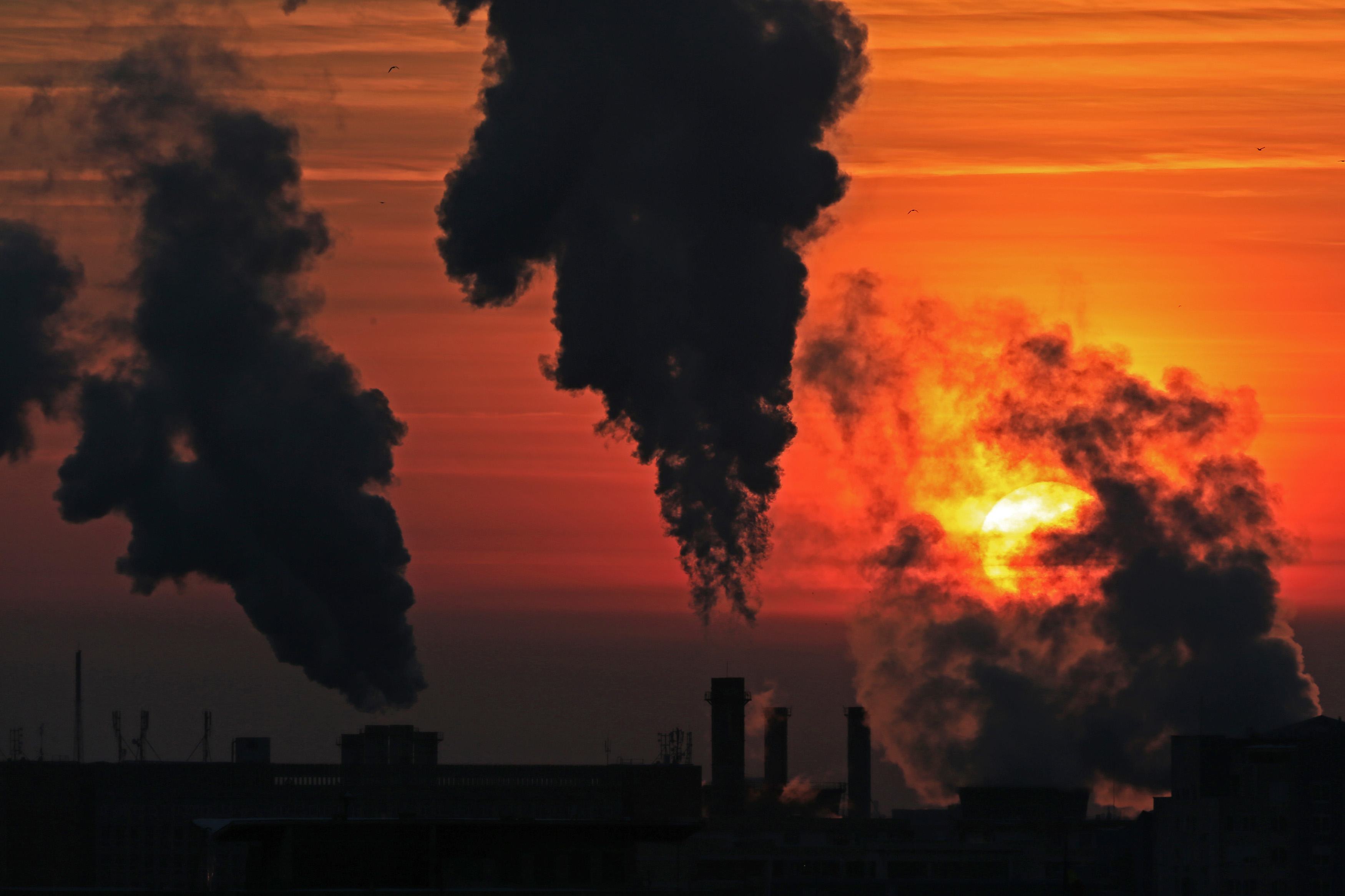 Steam from one of the city's heating power plants rises in the cold air as the sun sets at dusk in Bucharest