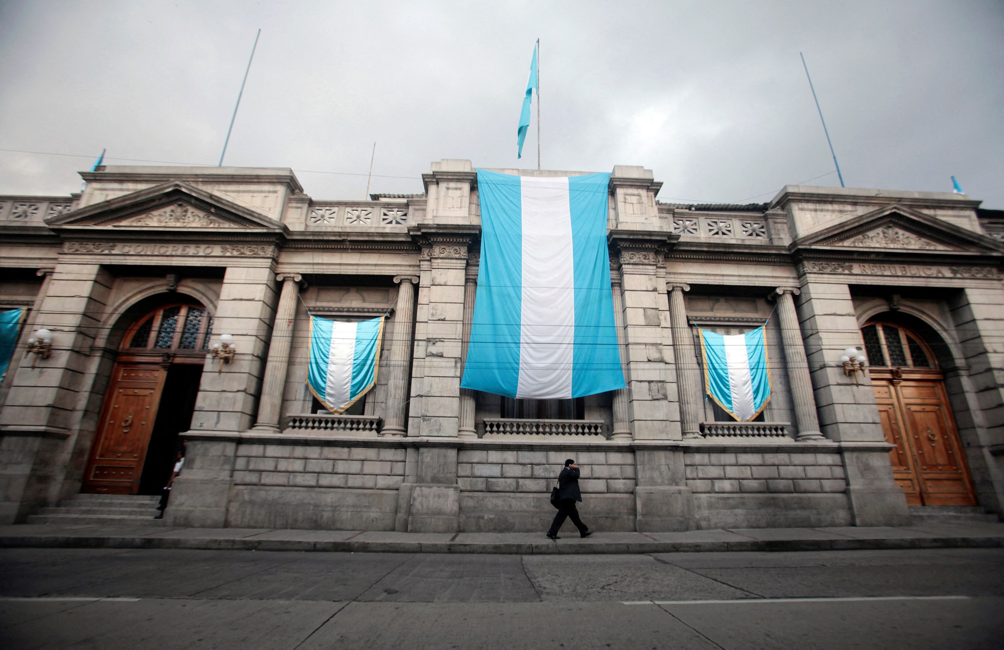 A man walks past the Guatemalan Congress which is decorated with Guatemalan flags as part of the 191th Guatemala Independence Day celebrations in Guatemala City