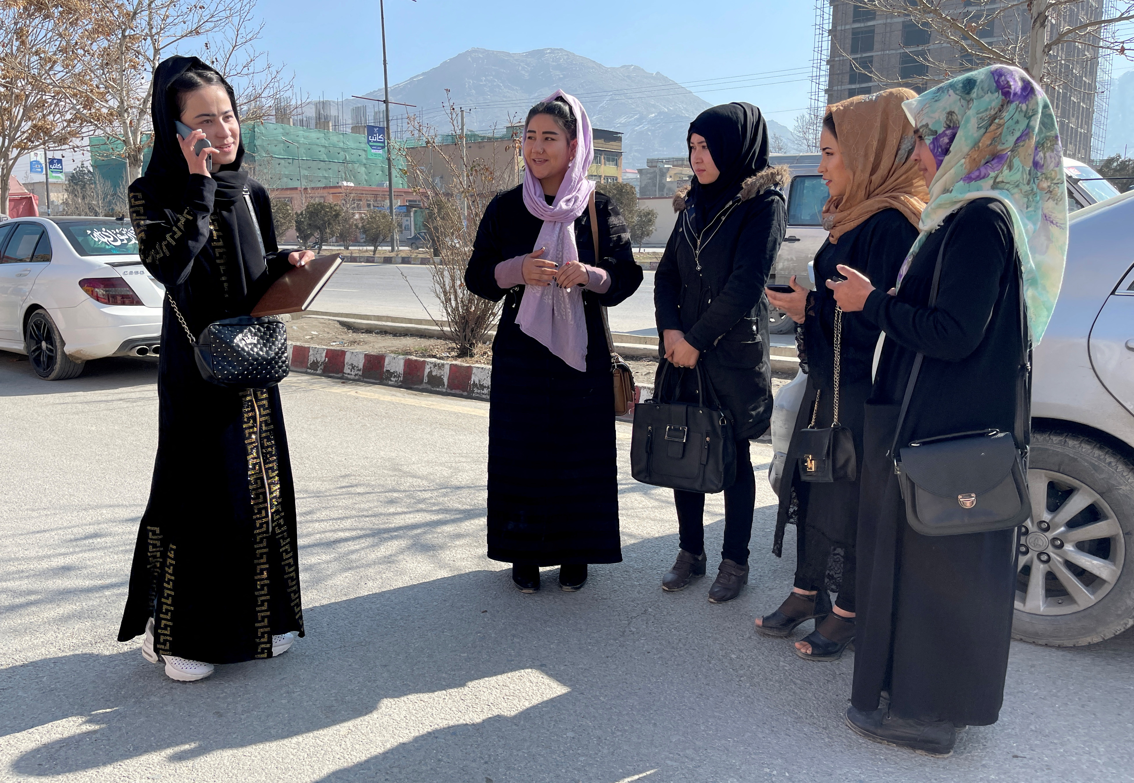 Waheeda Bayat, a 24-year-old student, stands with her classmates outside Gawharshad University in Kabul, Afghanistan, February 24, 2022. REUTERS/Stringer