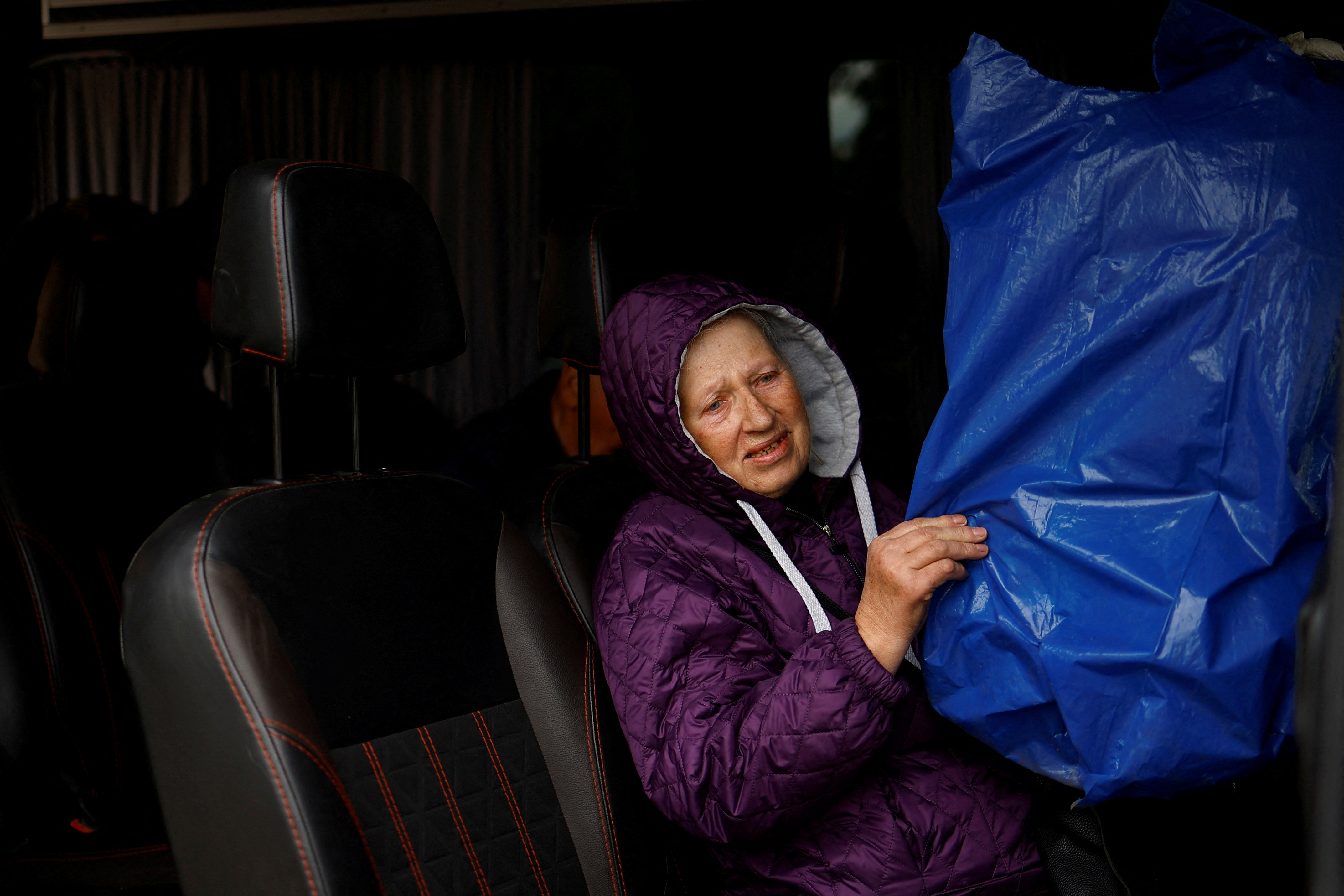 Vovchansk resident Hanna, 74-year-old holds a covered cage with a parrot as she sits inside an evacuation bus to Kharkiv due to Russian shelling near a border in Kharkiv region