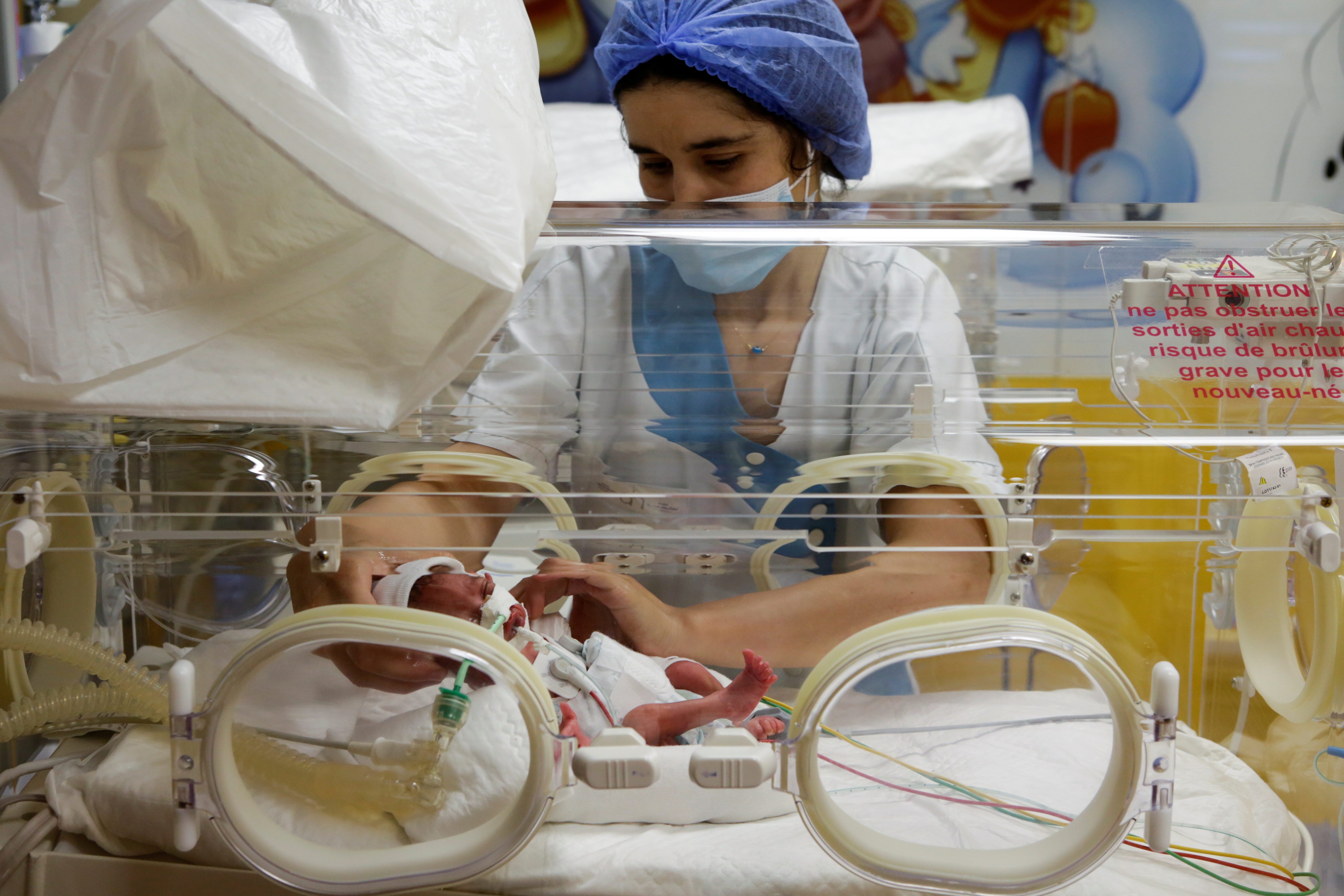 A nurse takes care of one of the newborn nonuplets, lying in an incubator, at the private clinic of Ain Borja in Casablanca