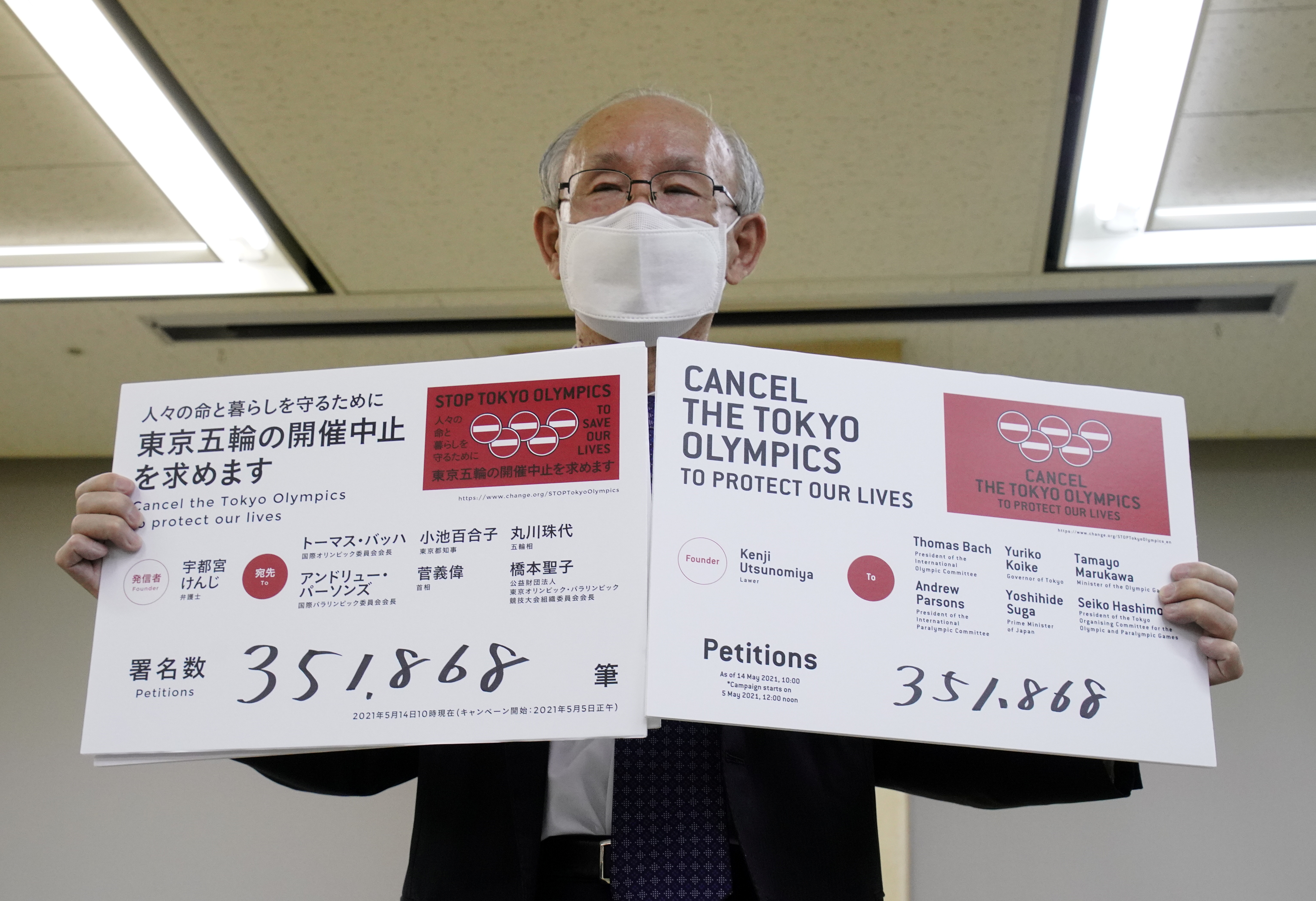 Lawyer Kenji Utsunomiya shows off placards during a news conference after he and anti-Olympics petition organizer to submit a petition calling for the Tokyo 2020 Olympics to be cancelled in Tokyo