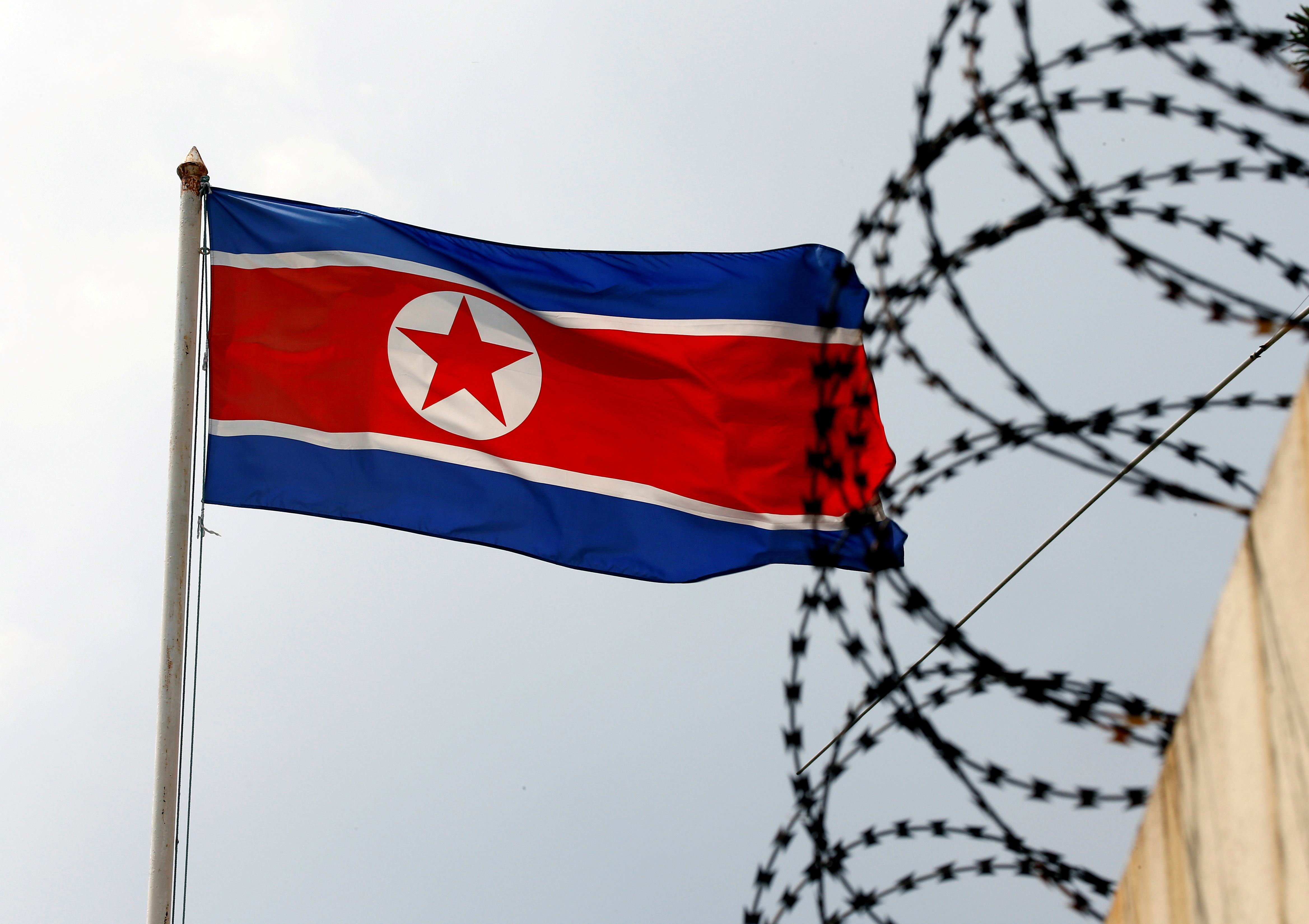 FILE PHOTO: FILE PHOTO: A North Korea flag flutters next to concertina wire at the North Korean embassy in Kuala Lumpur