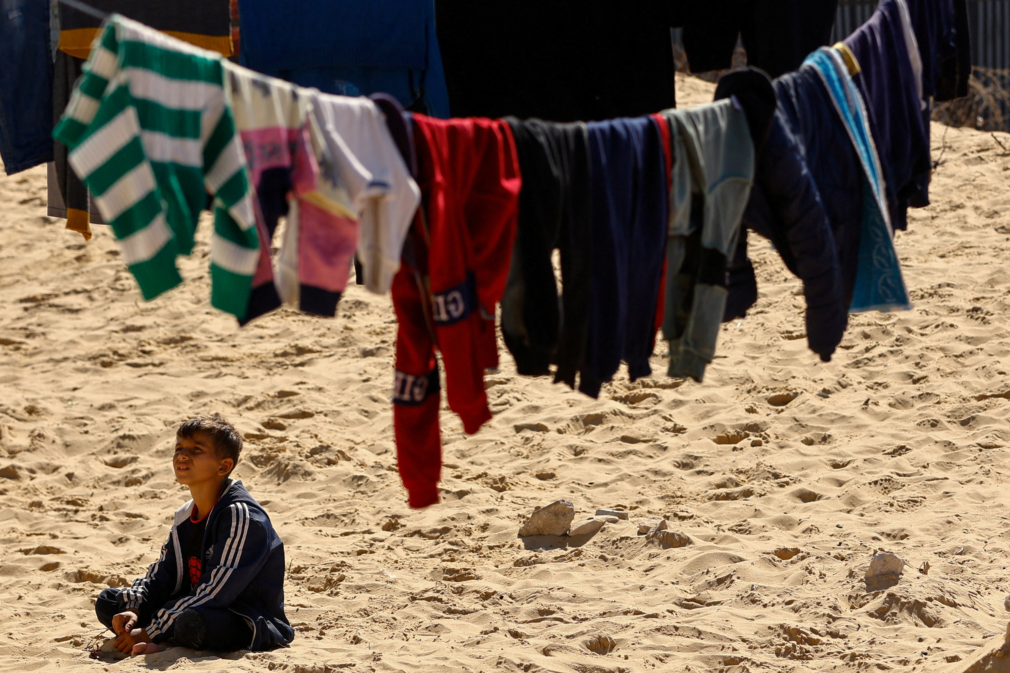 Displaced Palestinians, who fled their houses due to Israeli strikes, take shelter in a tent camp in Rafah