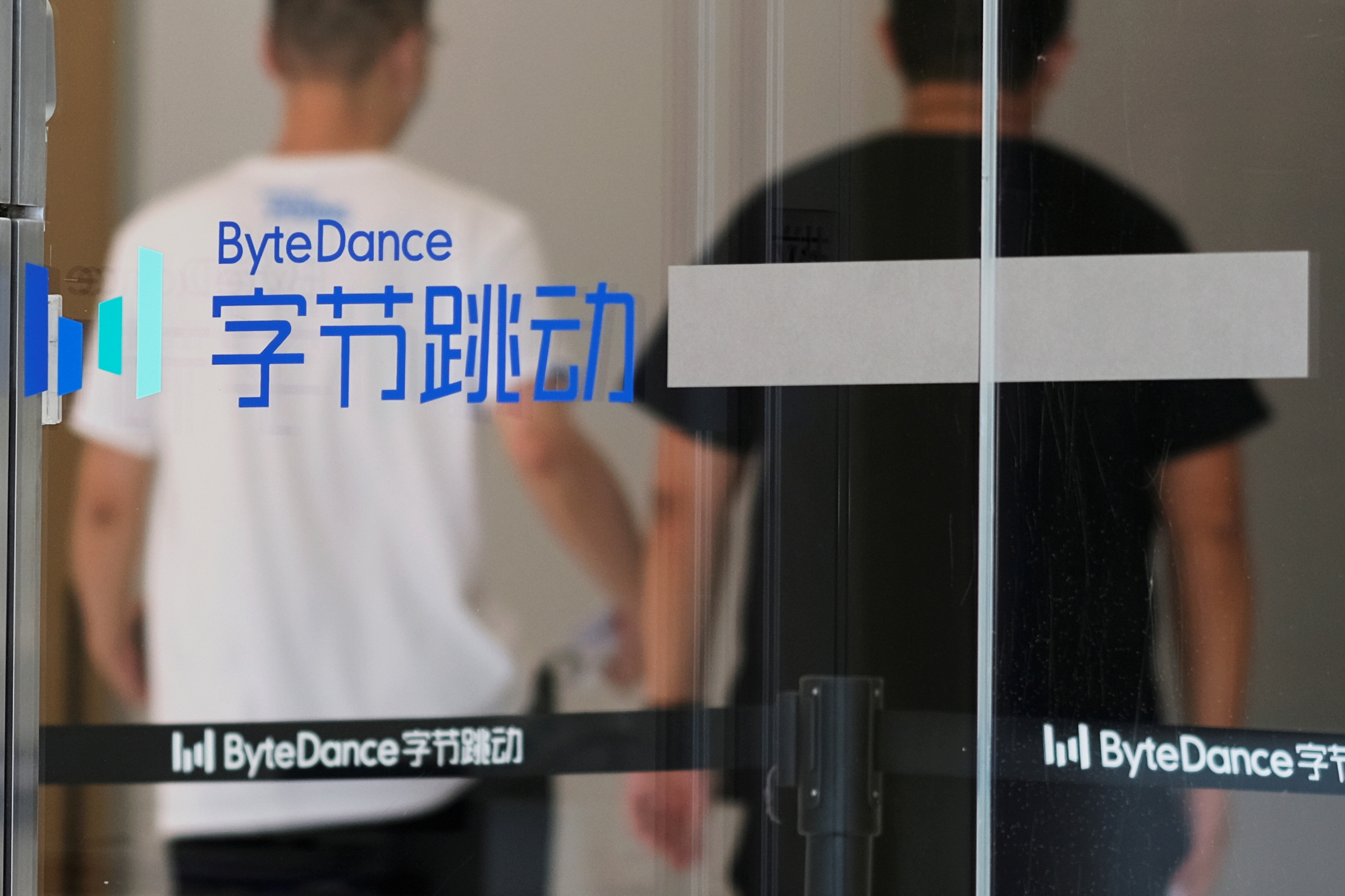 People walk past a logo of Bytedance, which owns short video app TikTok, at its office in Beijing