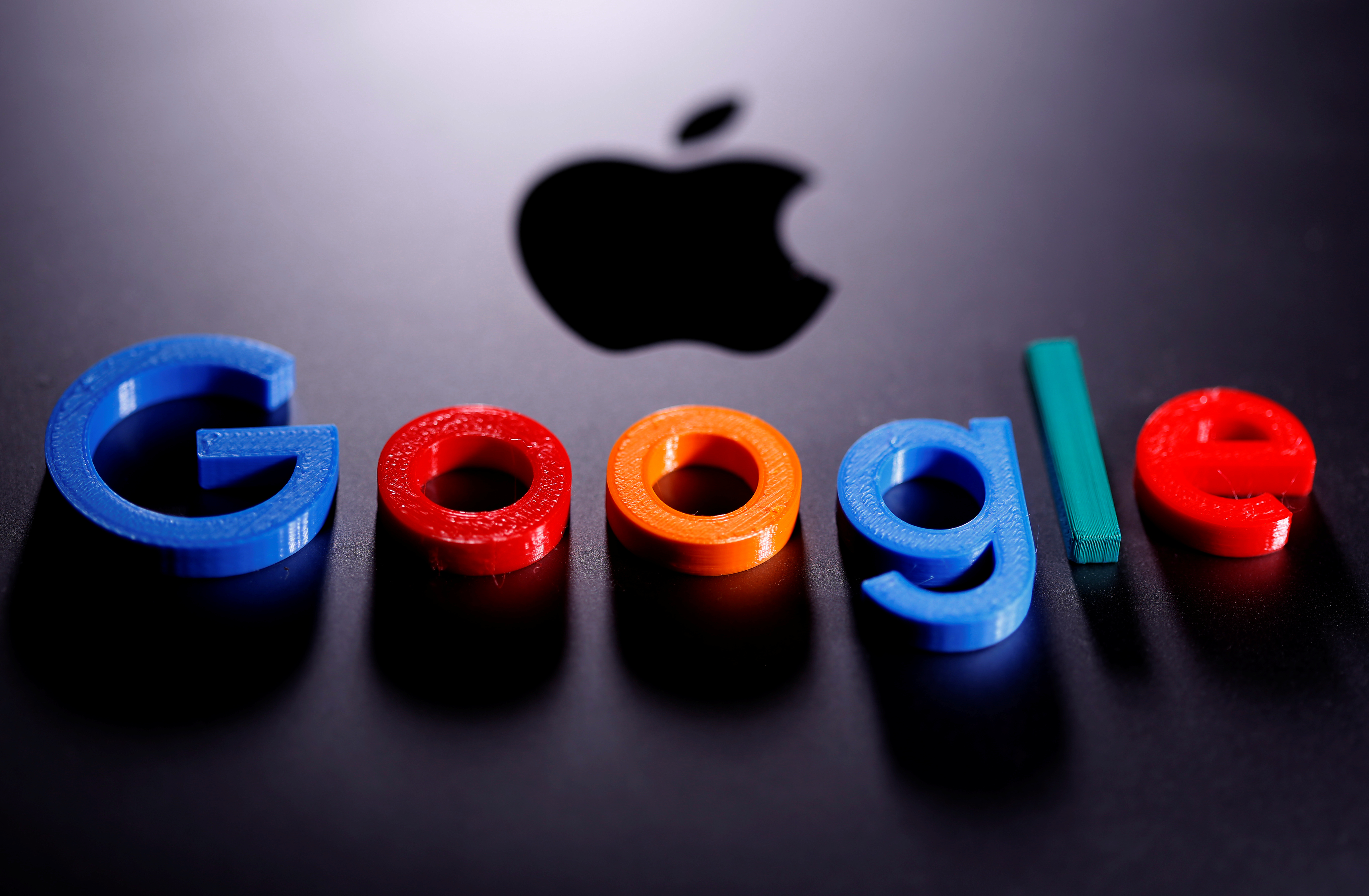 A 3D printed Google logo is placed on the Apple Macbook in this illustration