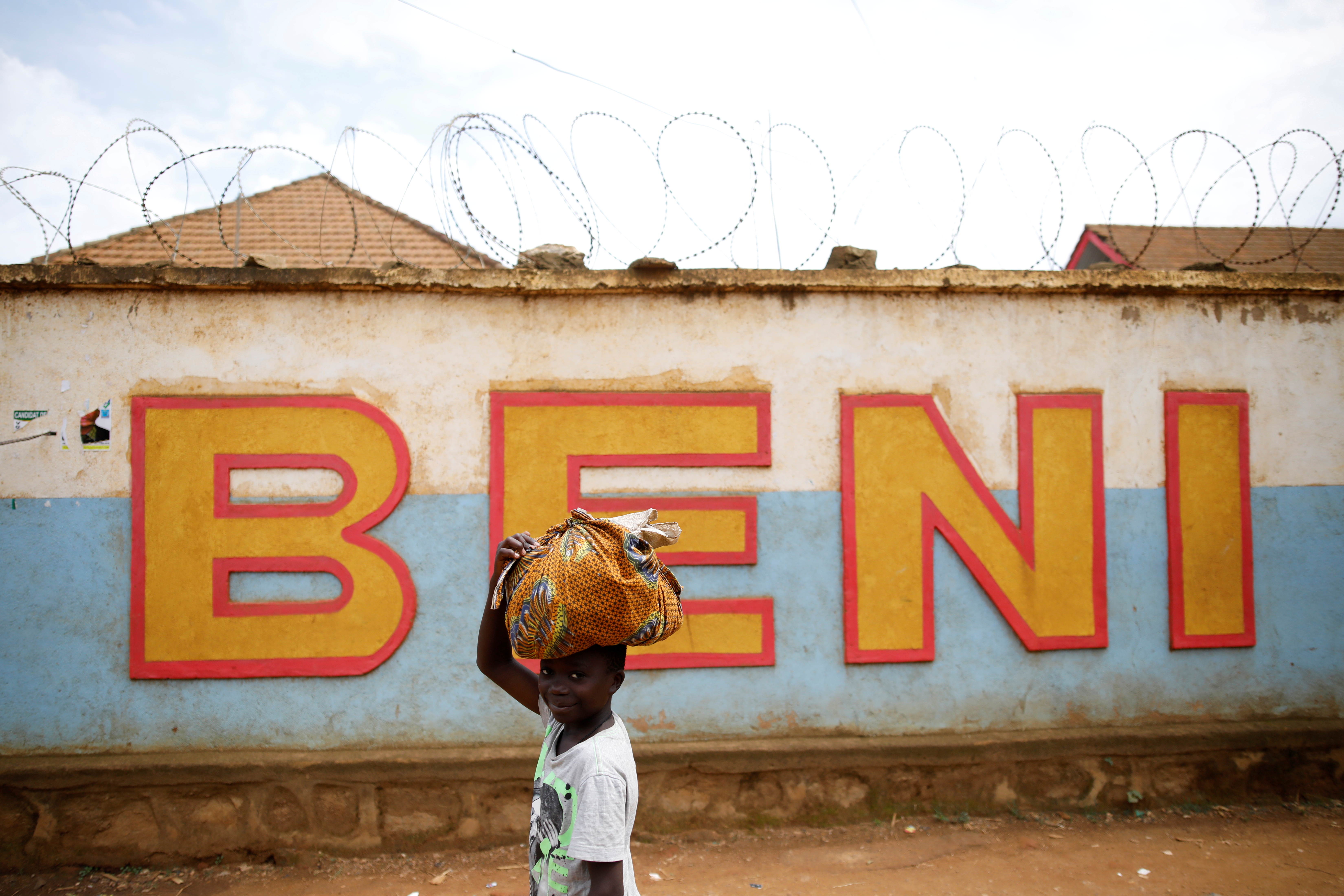 A Congolese boy walks past a wall near the Alima Ebola treatment centre in Beni, in the Democratic Republic of Congo, April 1, 2019. Picture taken April 1, 2019.REUTERS/Baz Ratner/File Photo