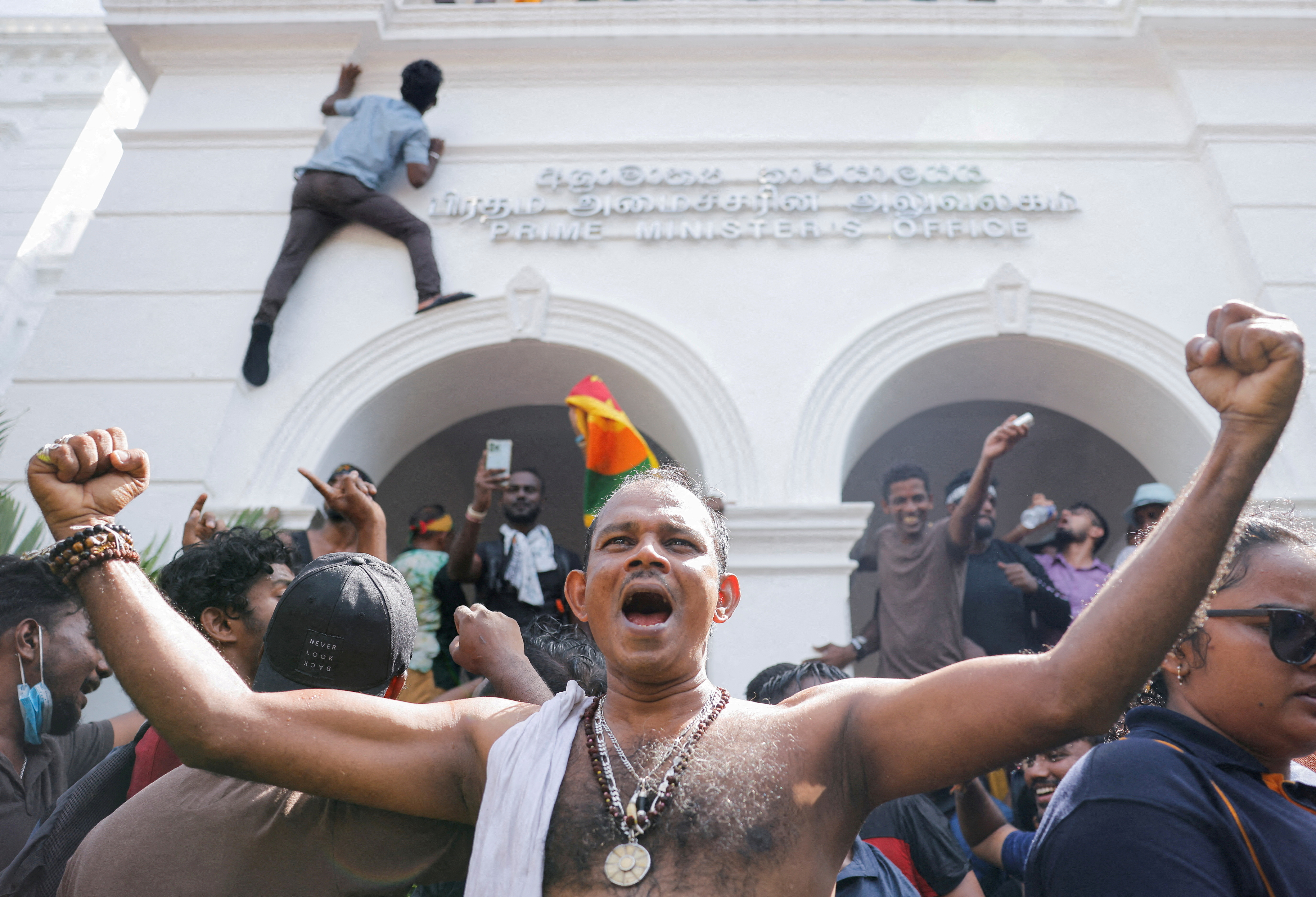 Demonstrators celebrate after they entered into Sri Lankan Prime Minister Ranil Wickremasinghe's office during a protest demanding for his resignation, after President Gotabaya Rajapaksa fled, amid the country's economic crisis, in Colombo, Sri Lanka, July 13, 2022. REUTERS/Dinuka Liyanawatte/File Photo