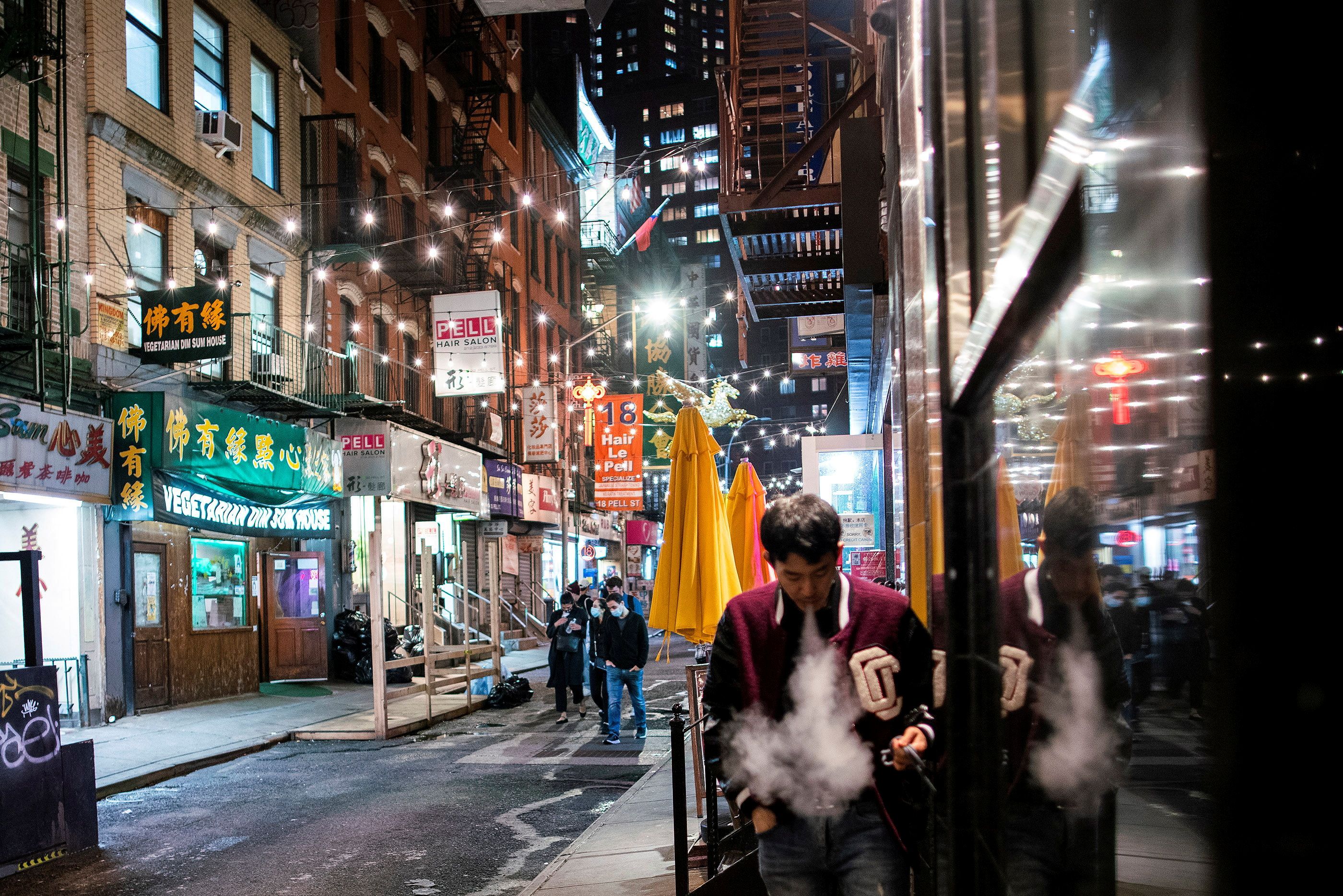 People make their way in a local street of Chinatown in the Manhattan borough of New York