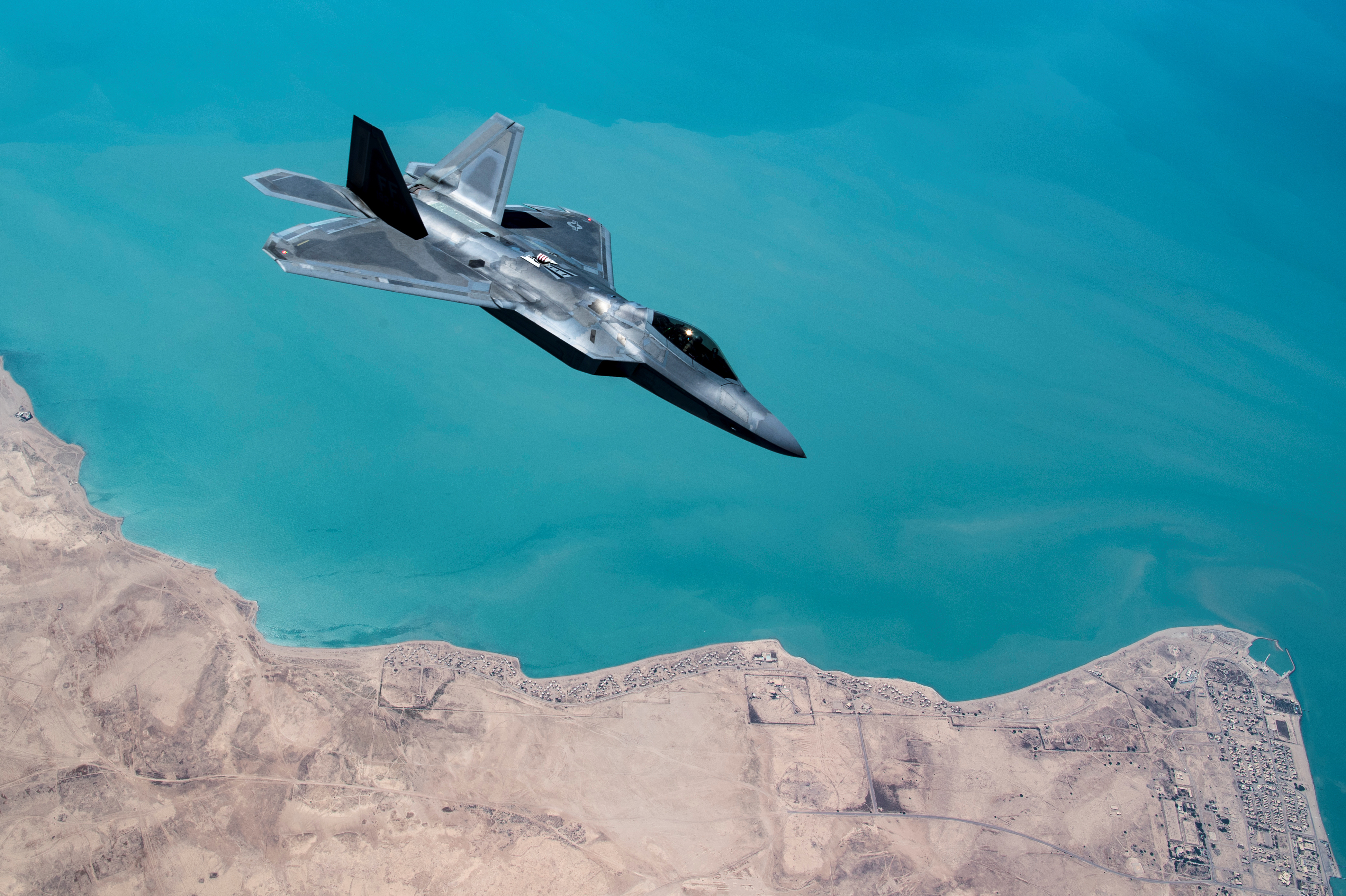 A U.S. F-22 Raptor, based out of Al Udeid Base in Doha, Qatar, receives fuel from a 28th Expeditionary Air Refuelling Squadron KC-135 Stratotanker during a combat air patrol mission over an undisclosed location in Southwest Asia