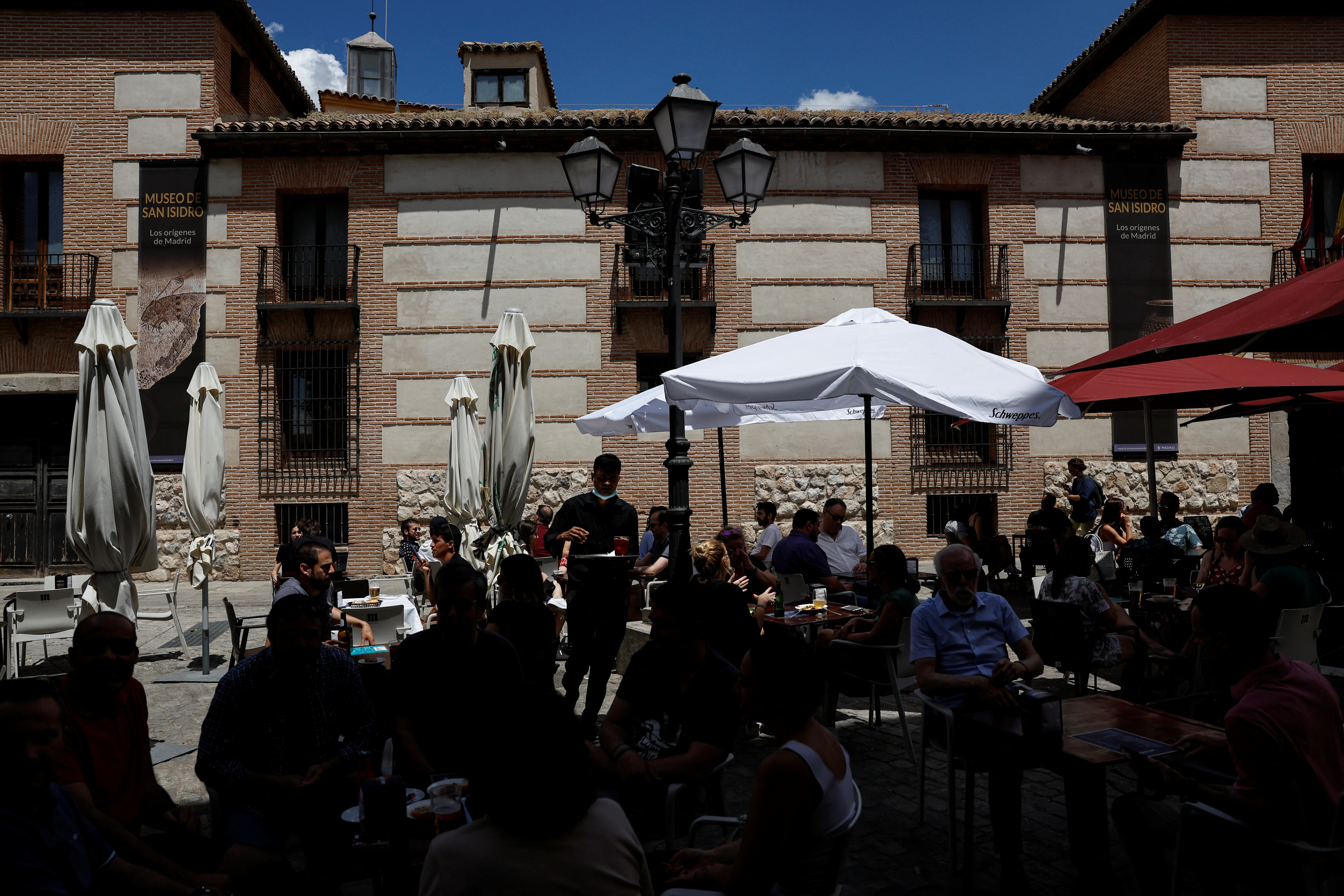 A waiter works at a crowded restaurant terrace in central Madrid