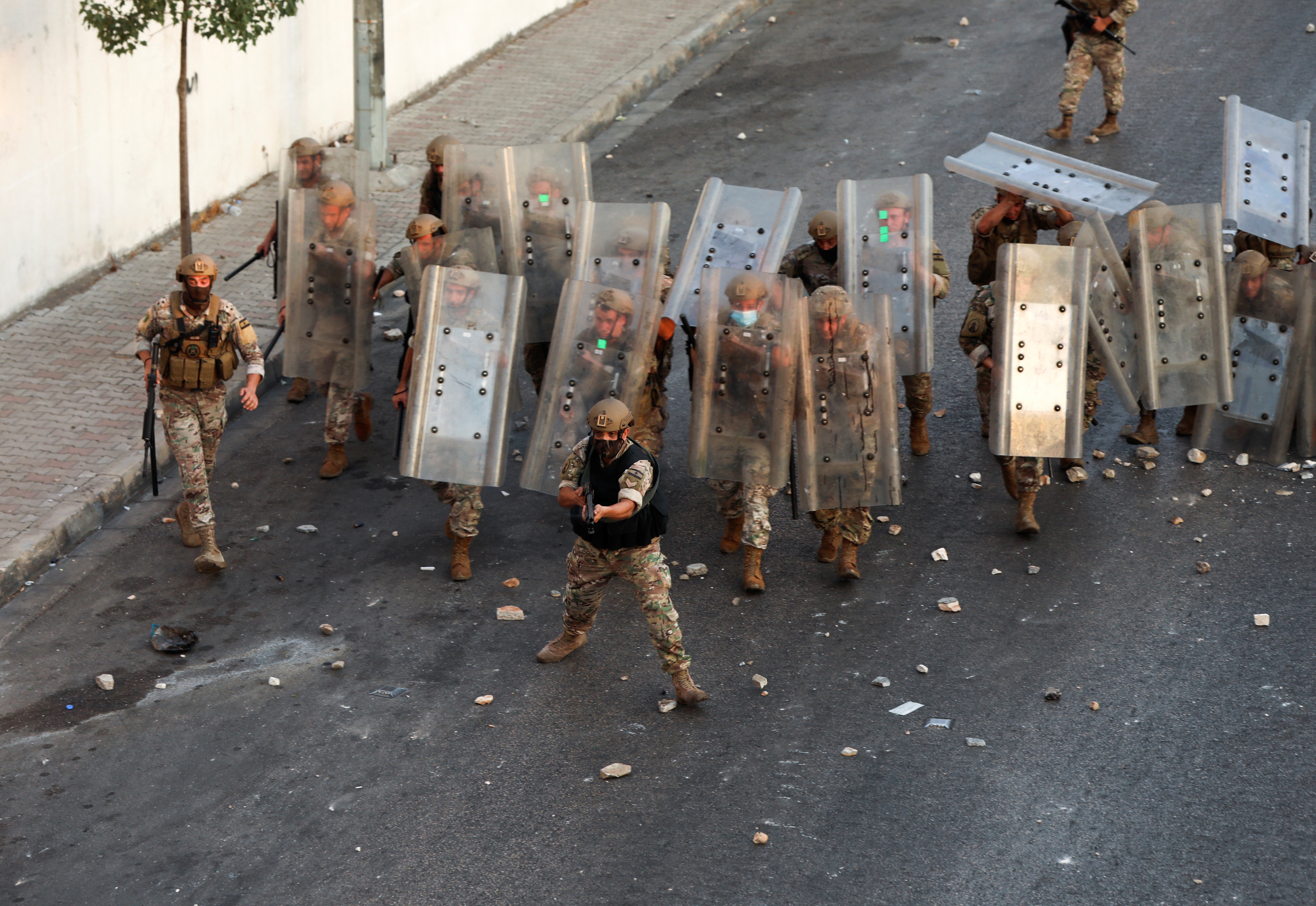 Lebanese army take cover behind shields as they deploy during a protest after Lebanese Prime Minister-Designate Saad al-Hariri abandoned his effort to form a new government, in Beirut