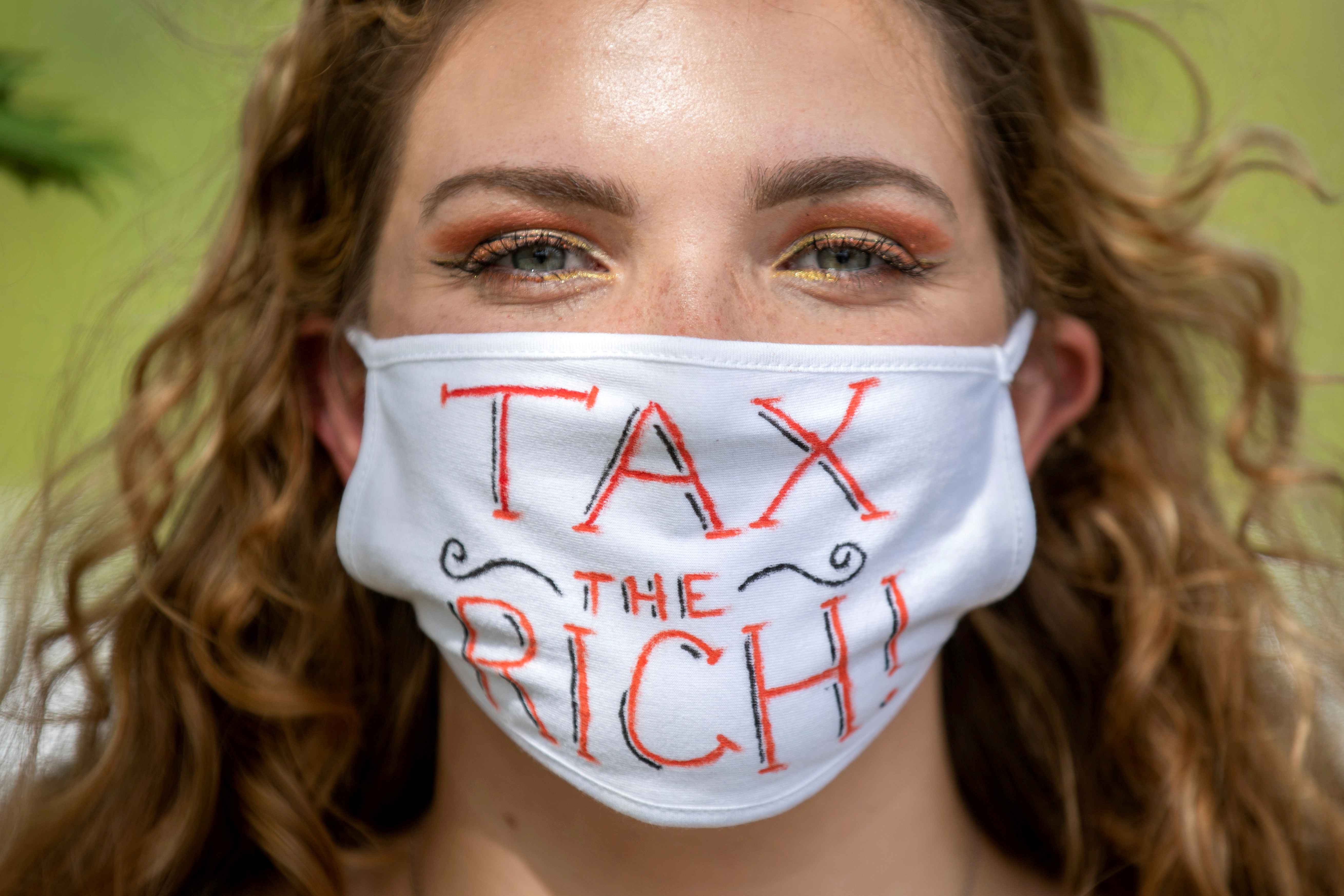 NDP supporter wears "Tax the Rich" mask