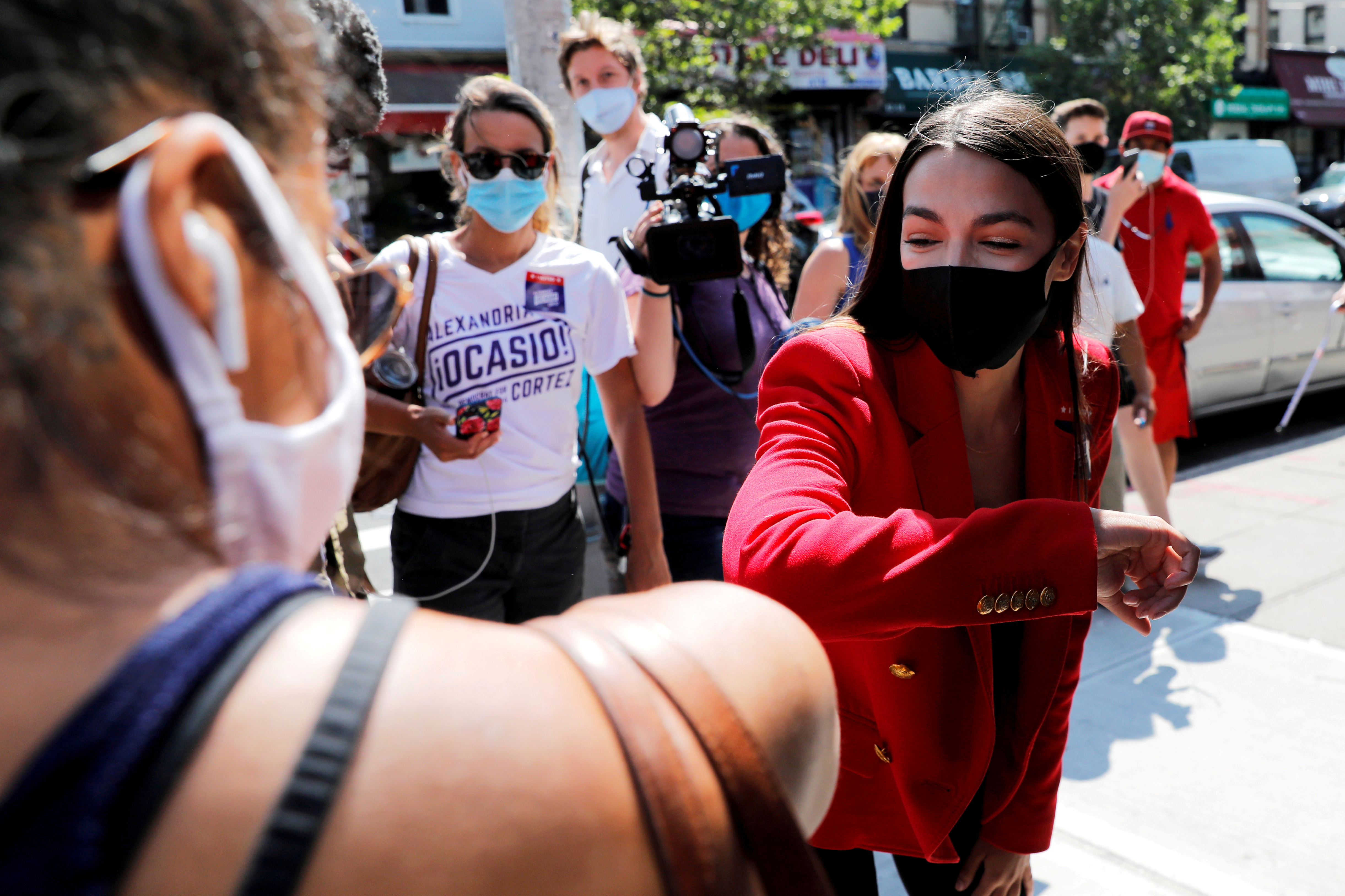U.S. Rep. Alexandria Ocasio-Cortez (D-NY) bumps elbows with local resident Upkar Chana while greeting voters during the Democratic congressional primary election in the Queens borough of New York City, New York, U.S., June 23, 2020. REUTERS/Mike Segar/File Photo/File Photo