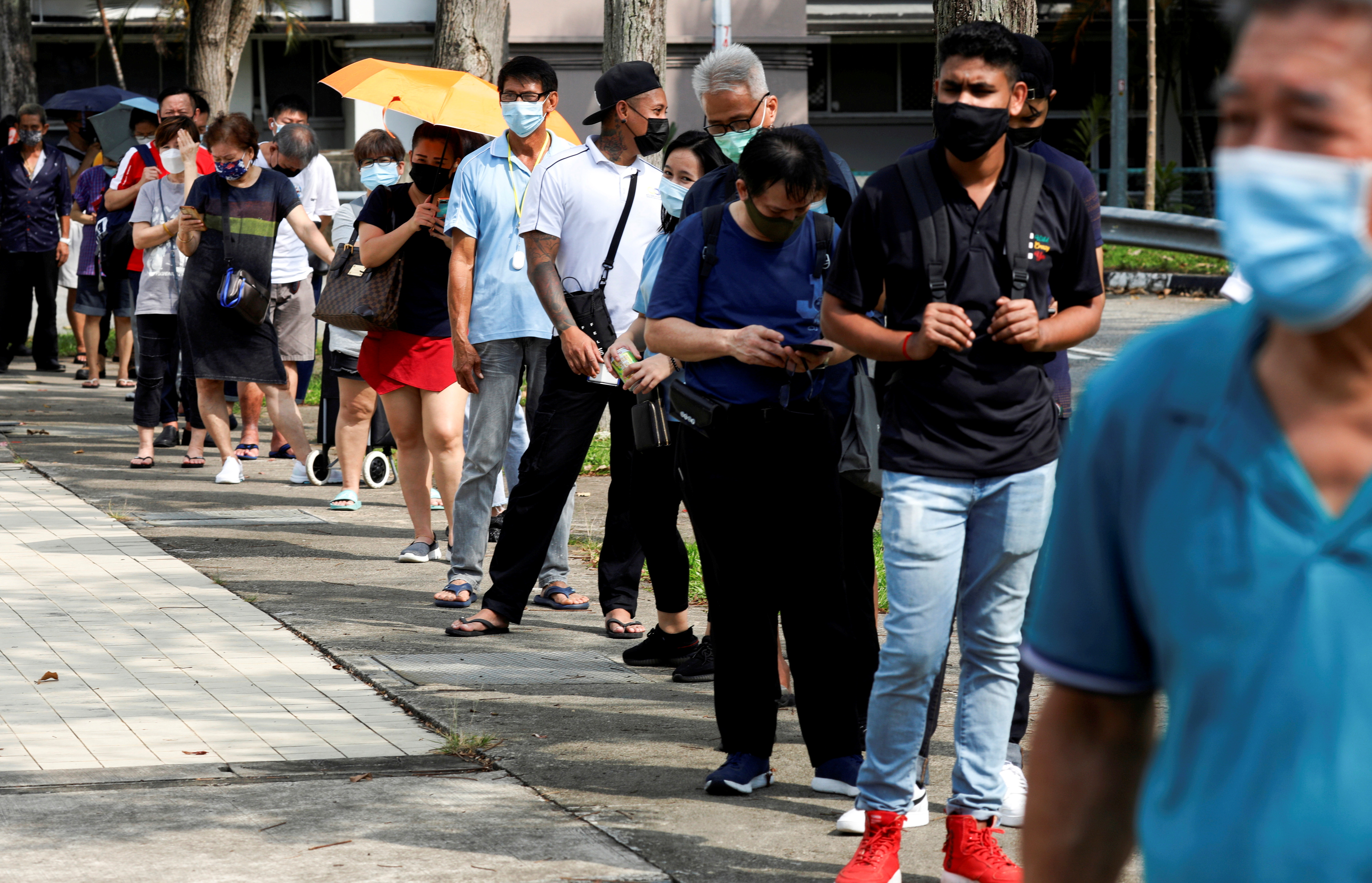 People queue up outside a quick test centre to take their coronavirus disease (COVID-19) antigen rapid tests, in Singapore September 21, 2021. REUTERS/Edgar Su/File Photo