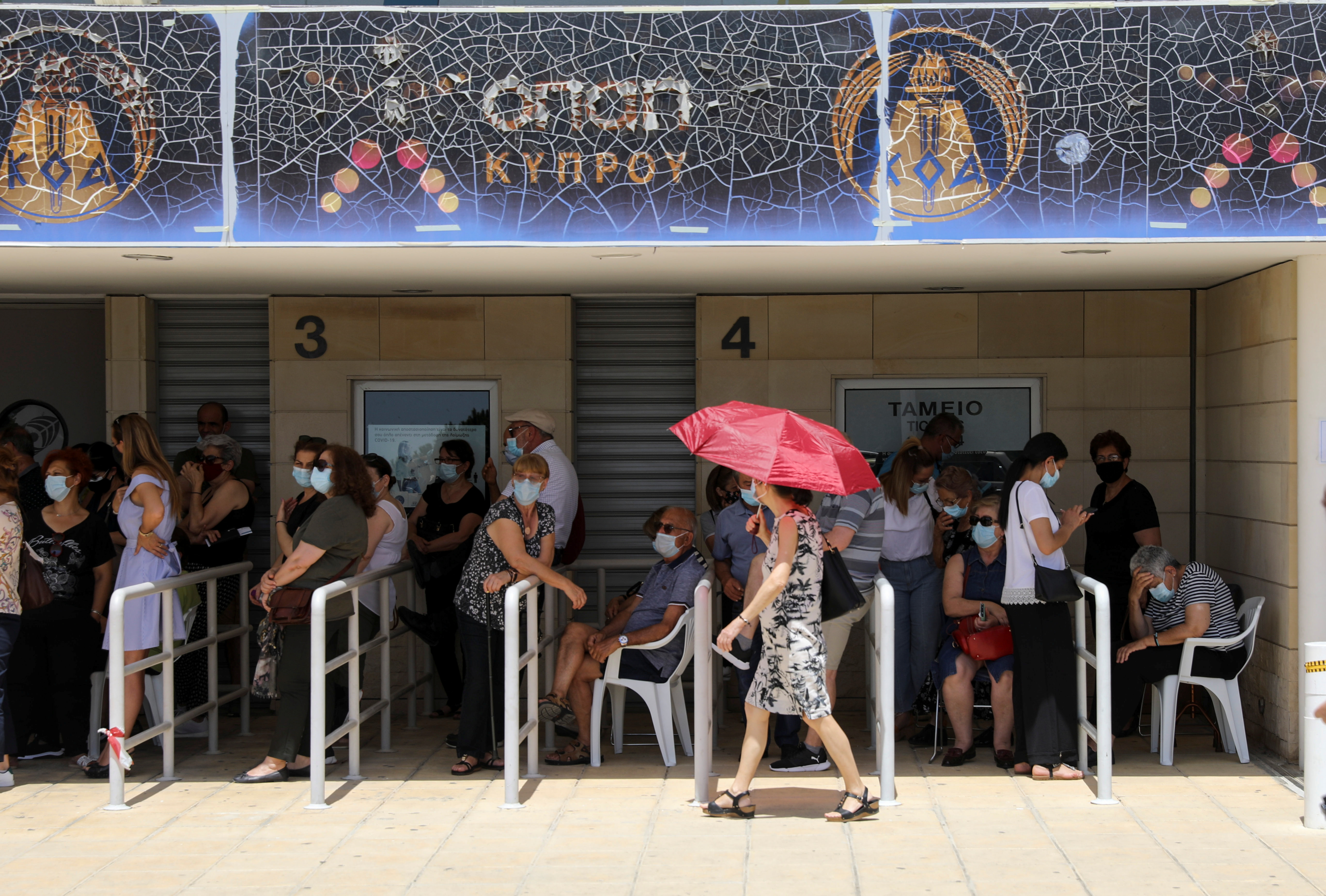 People wait outside a vaccination centre, amid the coronavirus disease (COVID-19) pandemic in Limassol
