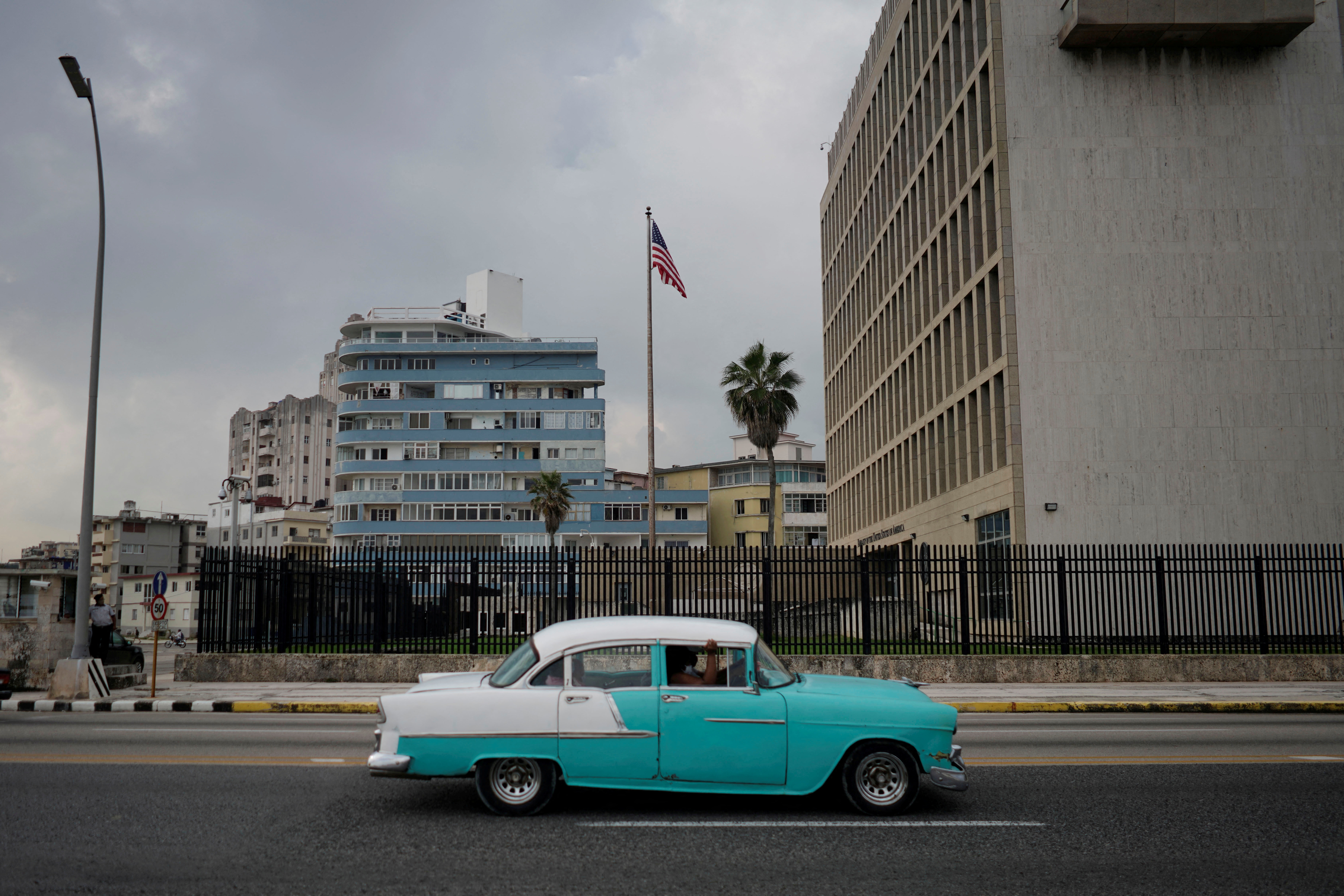 A vintage car passes by the U.S. Embassy in Havana