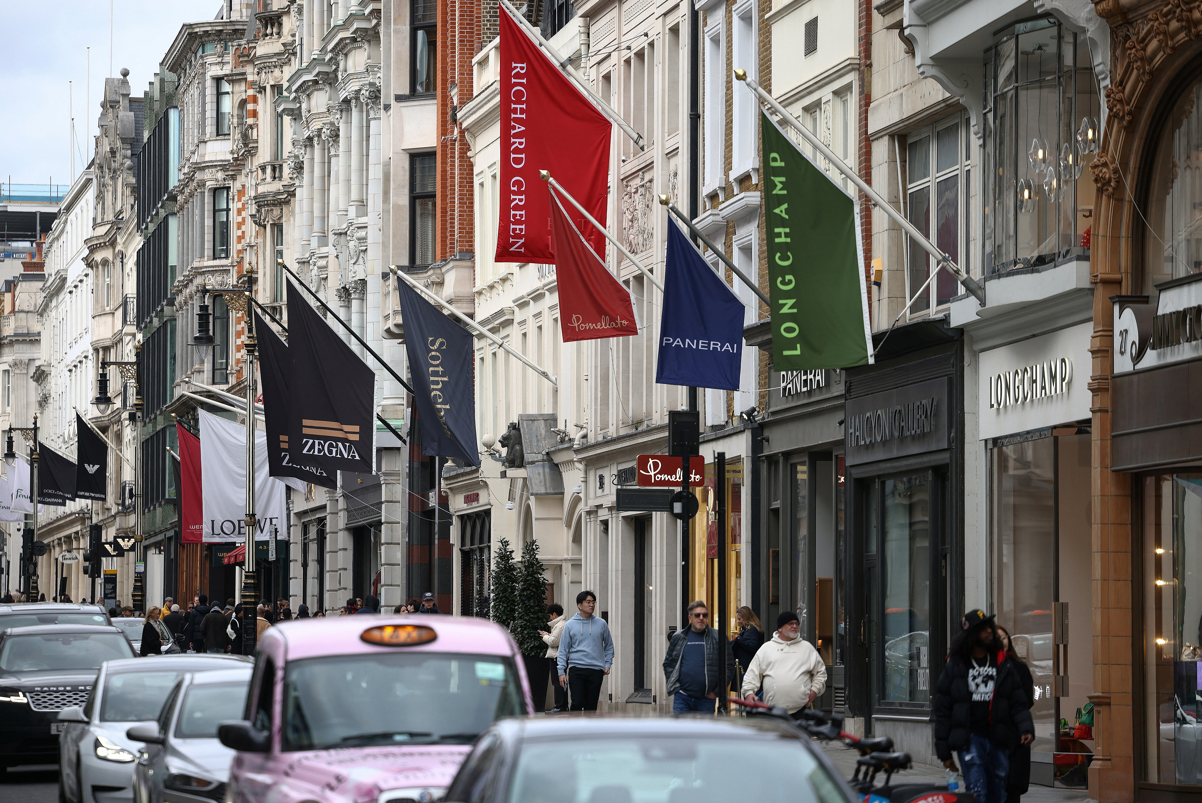 People walk past luxury shops on New Bond Street in London