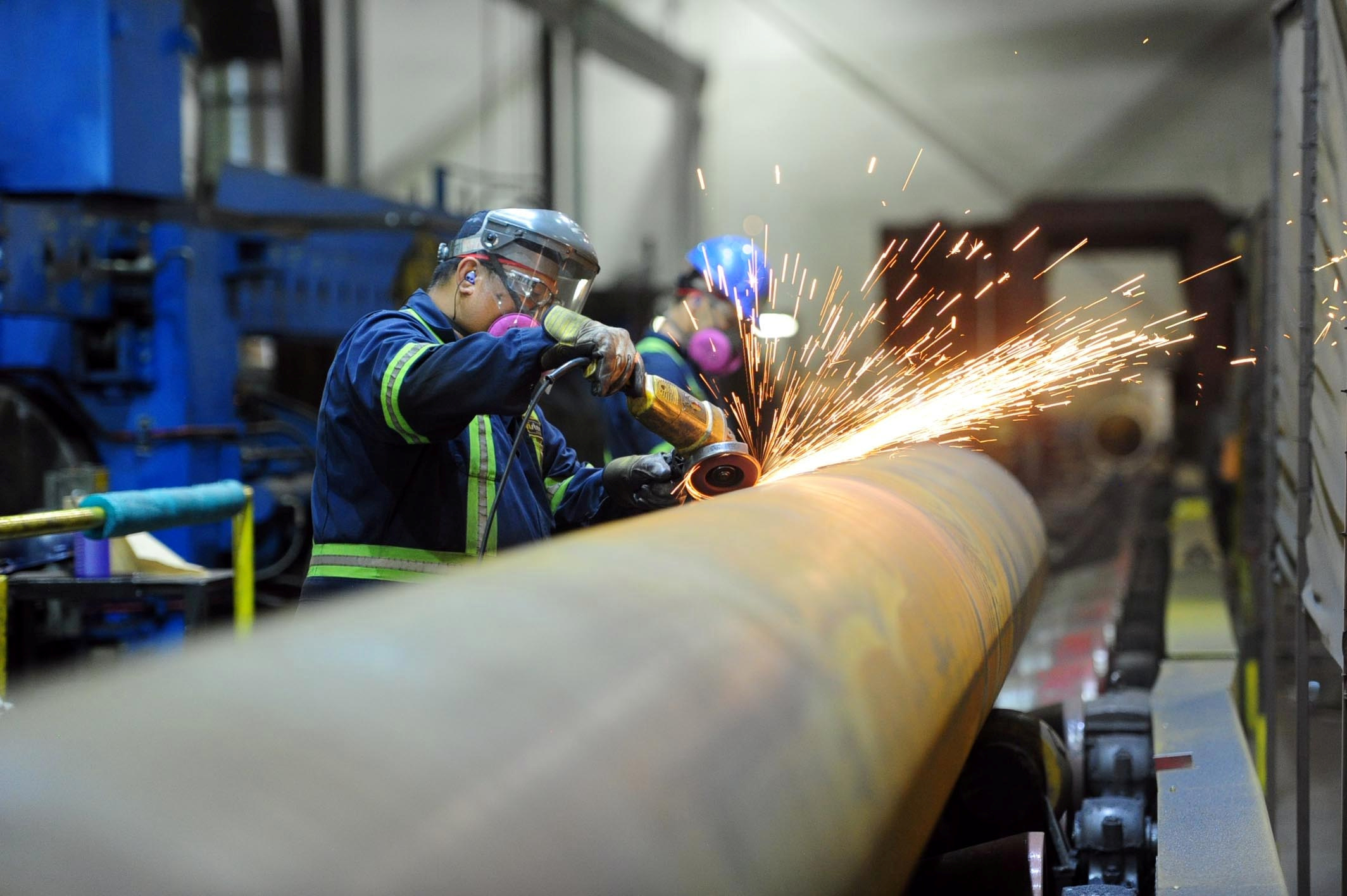 Workers are seen at Bri-Steel Manufacturing, a manufacturer and distributer of large diameter seamless steel pipes, in Edmonton