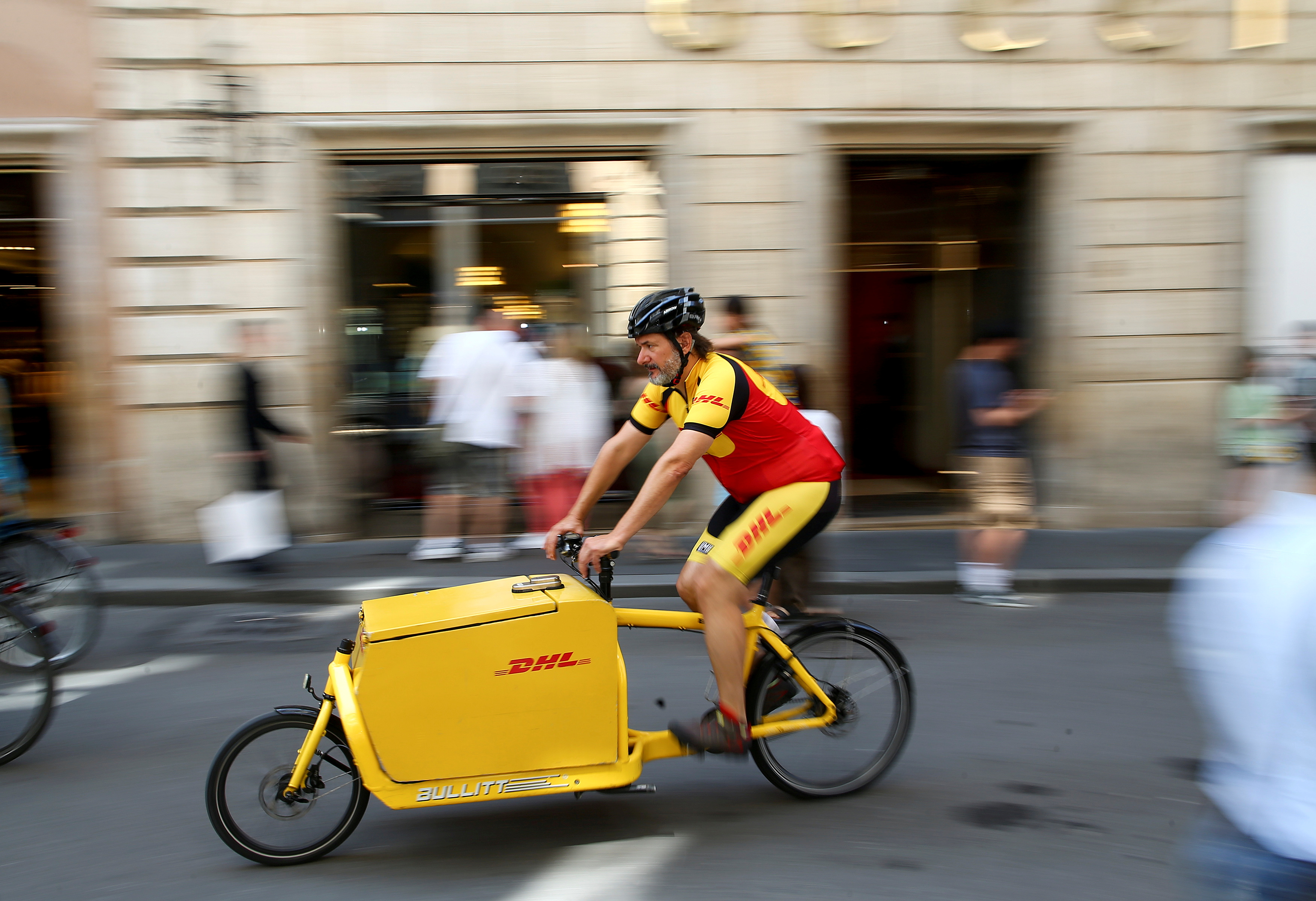 A DHL bike messenger rides in central Rome