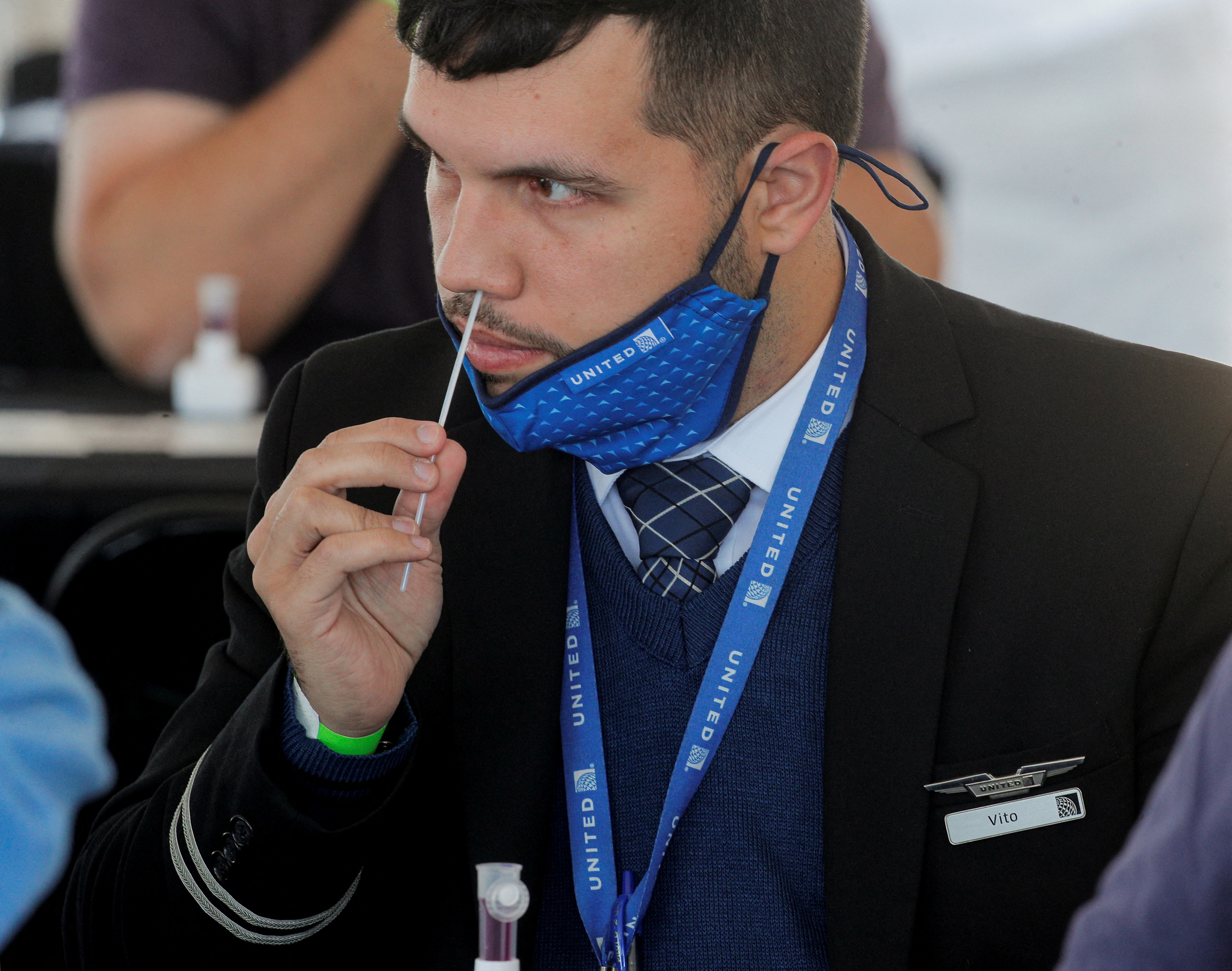A United Airlines employee swabs his nose for a coronavirus disease (COVID-19) test to attend a mass reunion event at MetLife Stadium in East Rutherford, New Jersey