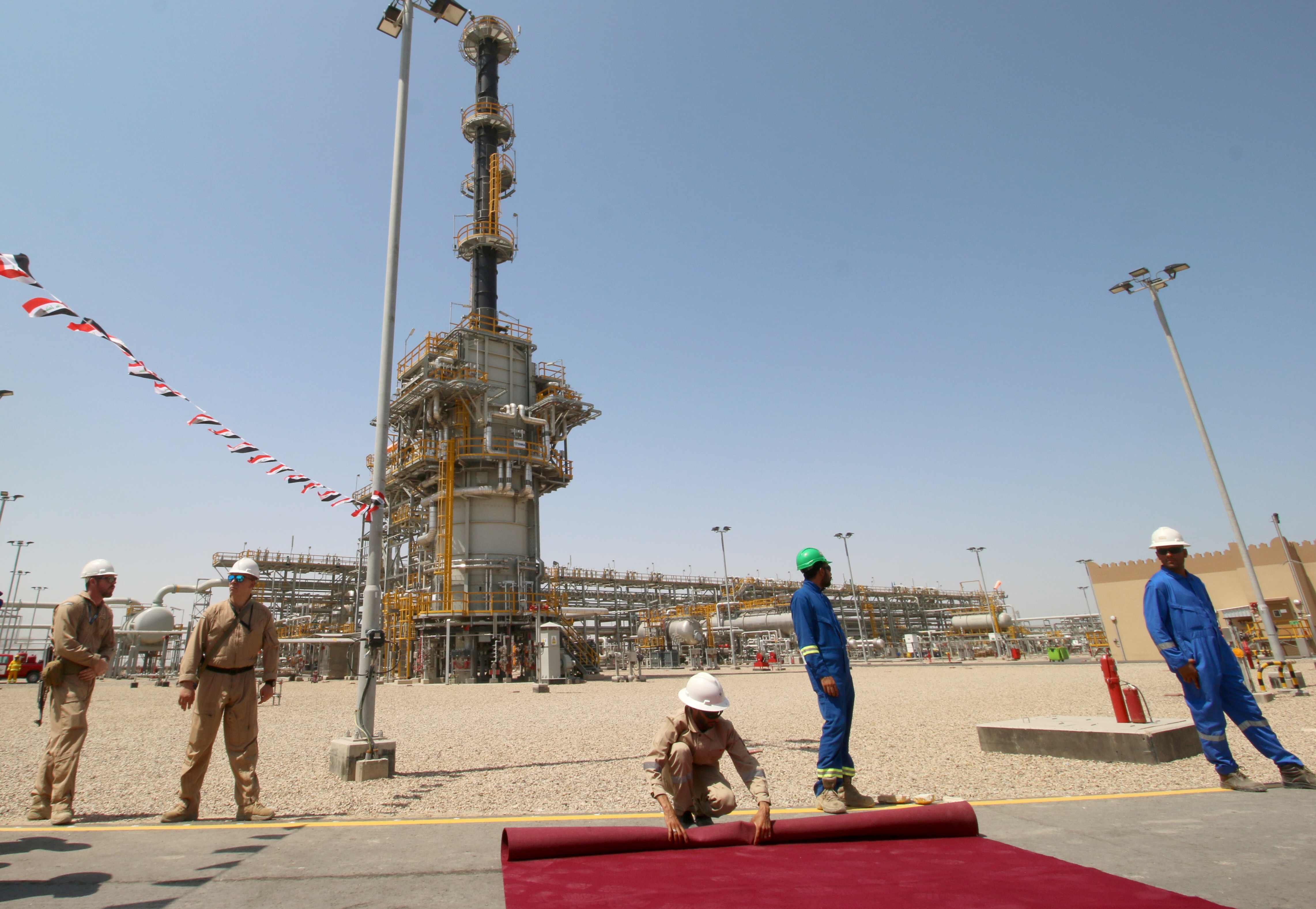 Members of security foreign personnel and Iraqi staff of the West Qurna-1 oilfield are seen during the opening ceremony near Basra