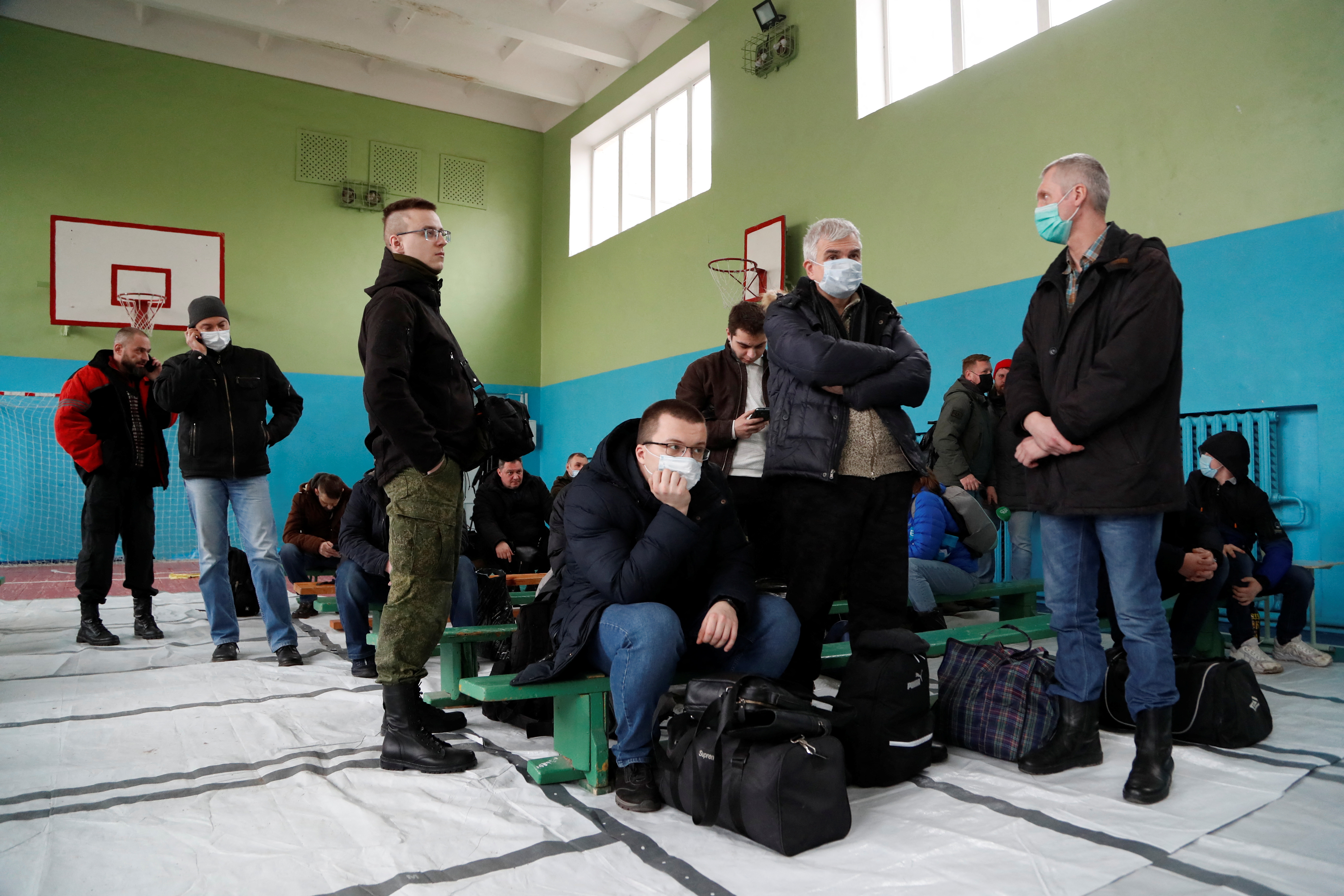Men gather at a military mobilization point opened in a school in Donetsk
