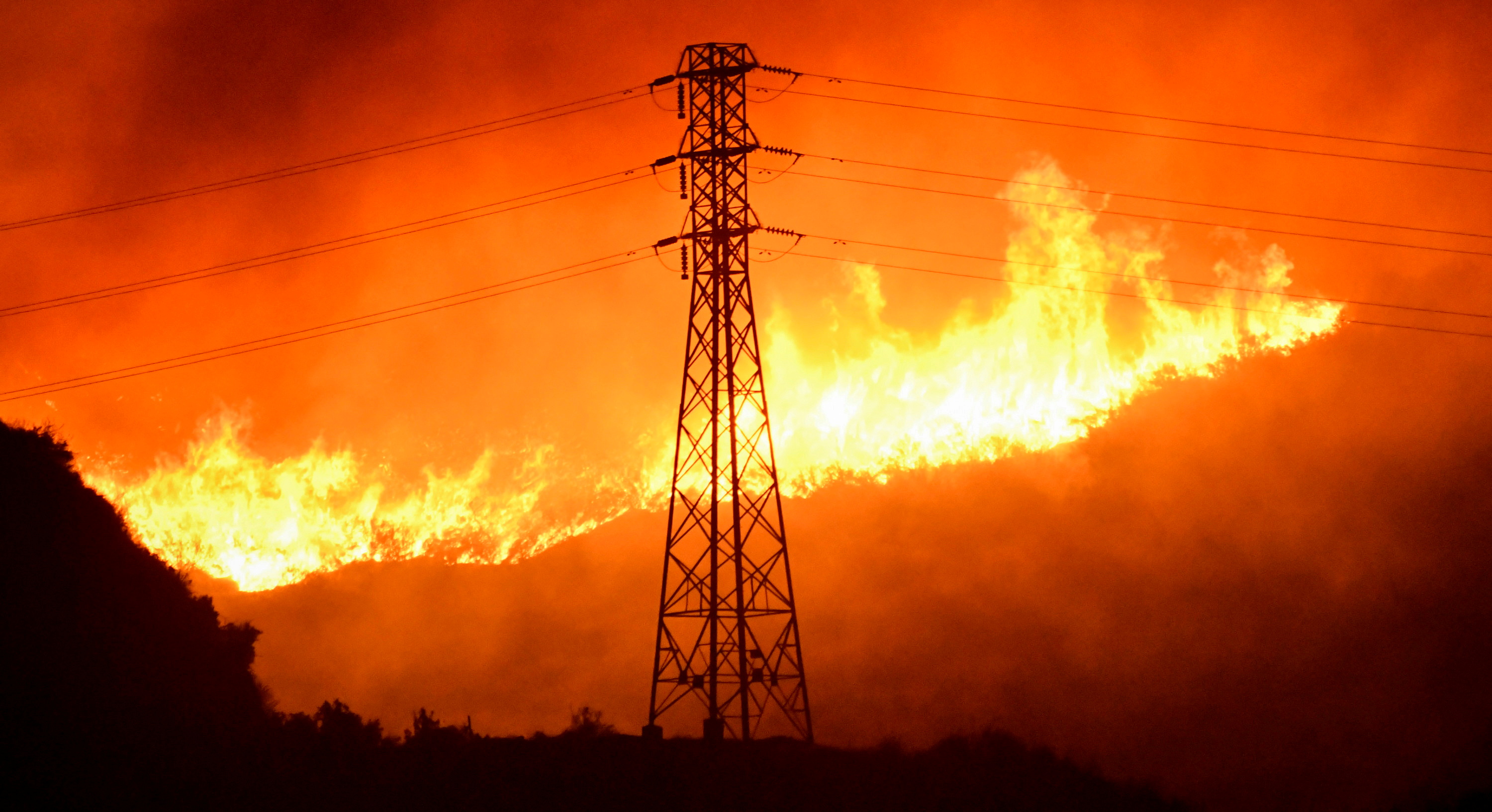 A wind-driven wildfire burns near power line tower in Sylmar, California, U.S., October 10, 2019.  REUTERS/ Gene Blevins/File Photo