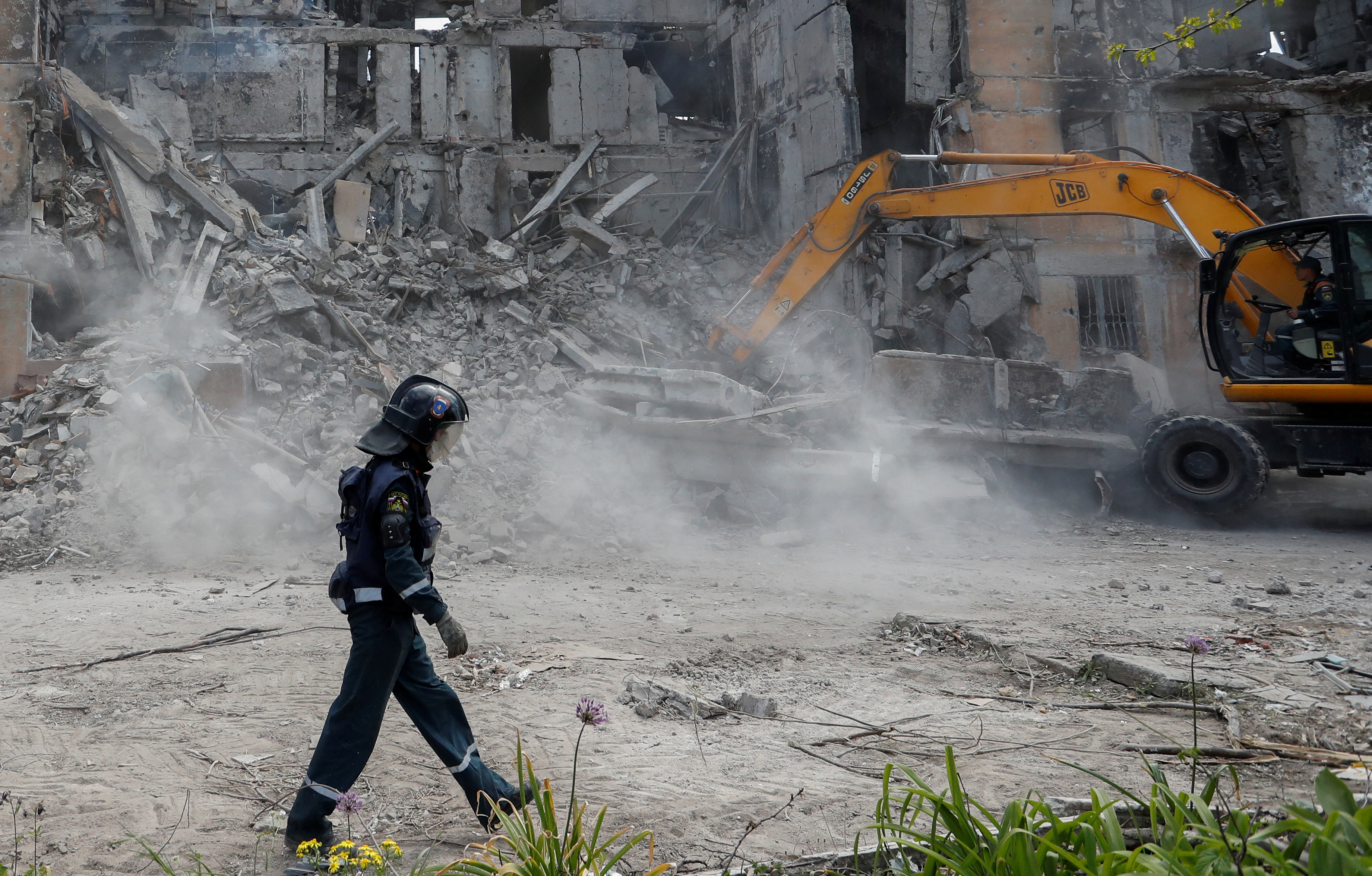 I soccorritori rimuovono i detriti di un edificio residenziale distrutto a Mariupol