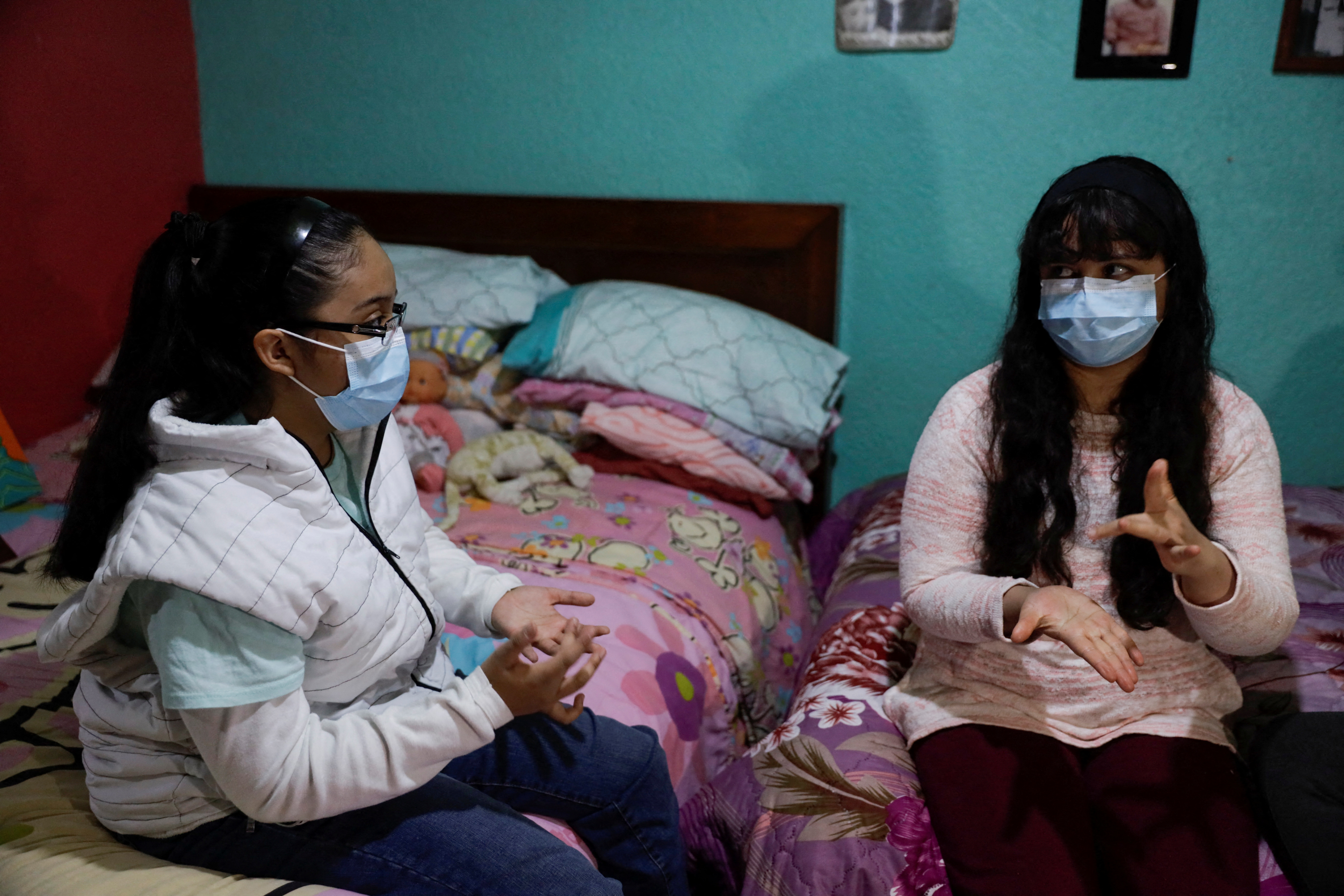 Guadalupe Estrella Salazar Calderon, 17, who is developing a sign-language translation app to connect Mexican Sign Language (MSL) speakers and interpreters with hearing users, talks sign-language with her sister Perla, at her house in the municipality of Nezahualcoyotl, Mexico December 30, 2021. REUTERS/Luis Cortes