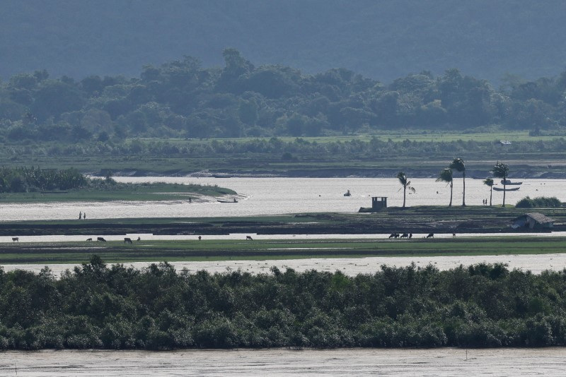 People of Maungdaw township of Myanmar are seen from the Teknaf area of Bangladesh, at the Myanmar-Bangladesh border