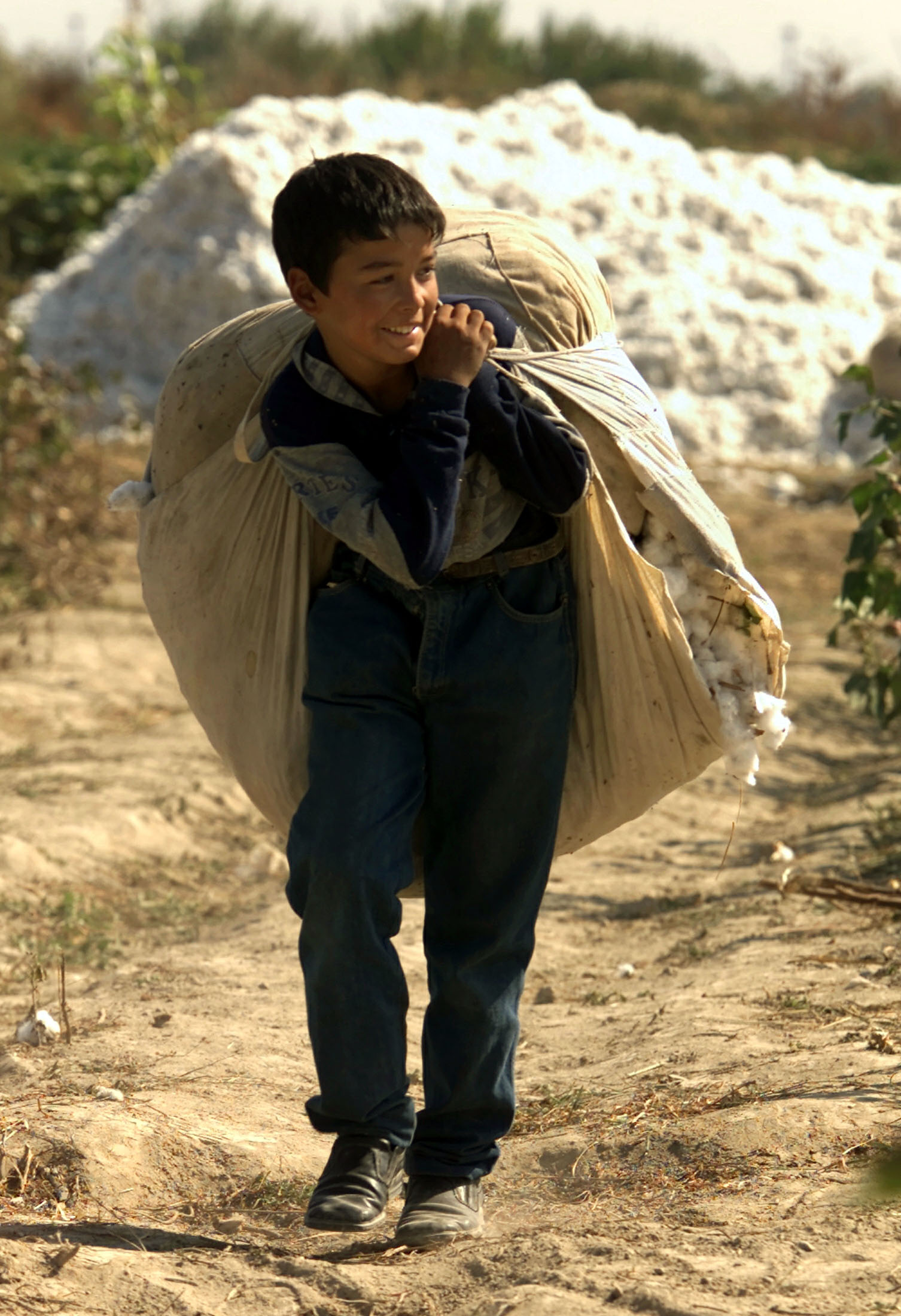 -PHOTO TAKEN 30SEP03- An Uzbek boy carries a sack with raw cotton on a field near Yallama